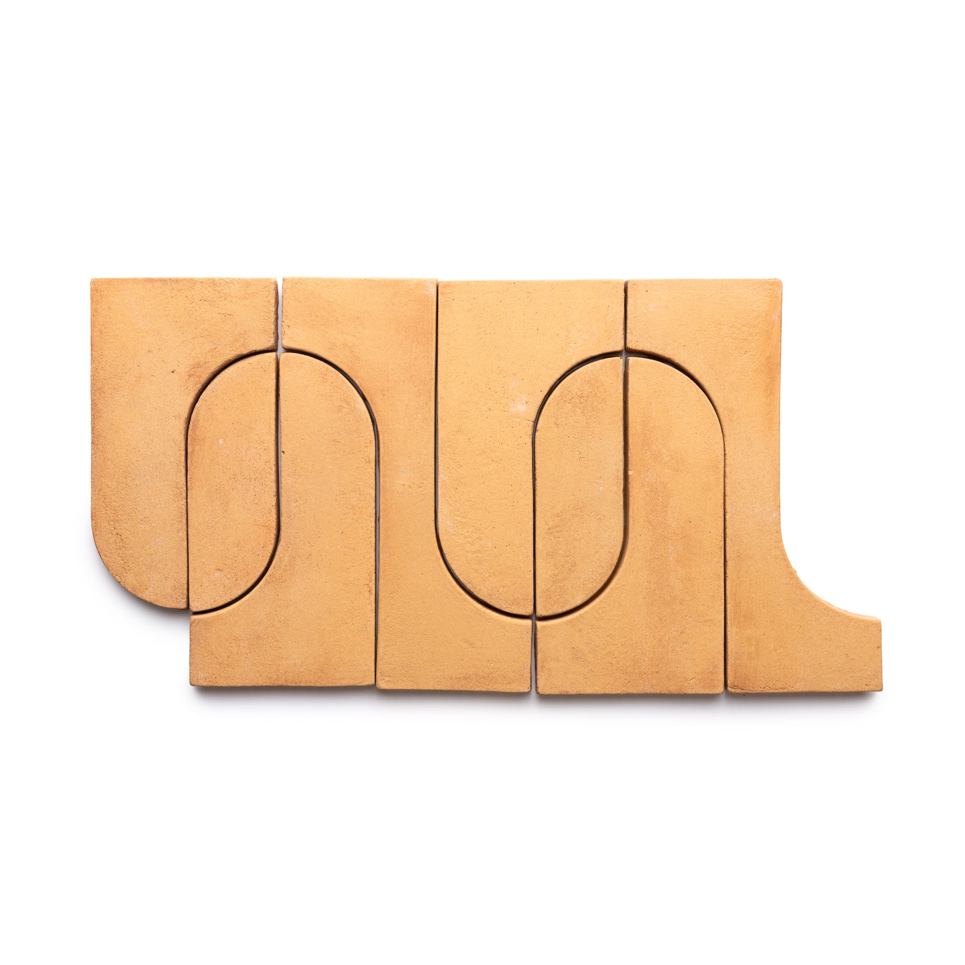 Five Durango + Adobe terracotta tiles by Zia Tile, each with a carved curved groove, arranged side by side to form a continuous wavy line.