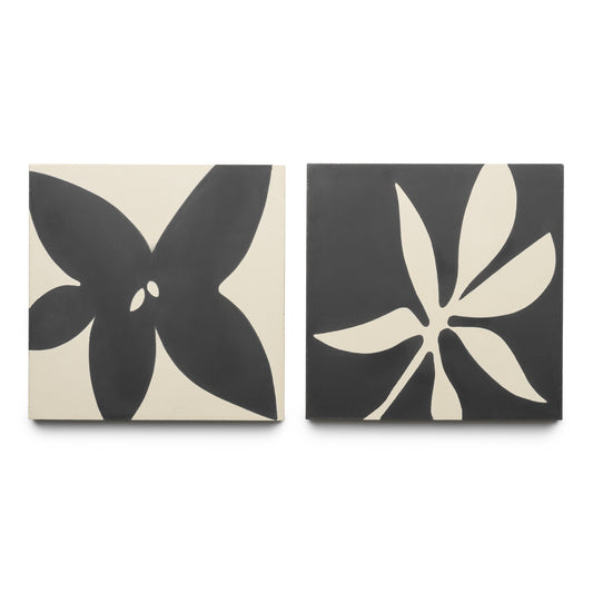 The Flora 8x8 Set Black + Bone by Zia Tile features two square tiles: one with a bold four-petal flower and the other with an abstract, multi-tipped leaf, both in striking black and white designs.