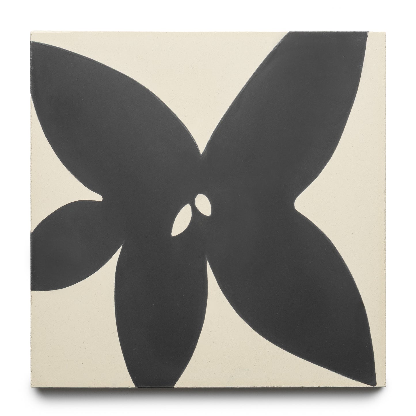 The Flora 8x8 Set Black + Bone by Zia Tile is a square tile with a bold, abstract black flower—four large petals and two small central shapes—set on an off-white background.