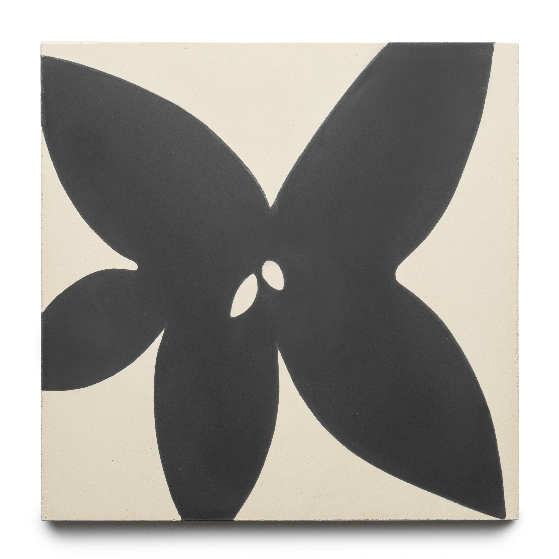 The Flora 8x8 Set Black + Bone by Zia Tile is a square tile with a bold, abstract black flower—four large petals and two small central shapes—set on an off-white background.