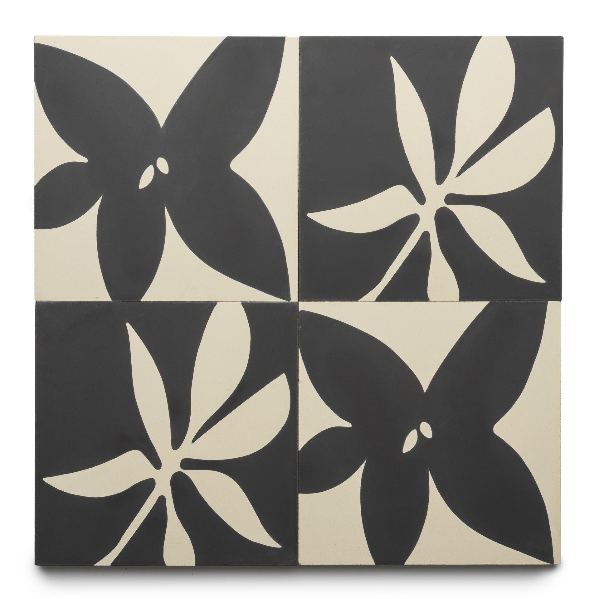 The Flora 8x8 Set Black + Bone by Zia Tile features four square tiles with bold, abstract black floral designs on a cream background, creating a striking modern pattern when arranged in a rectangle.
