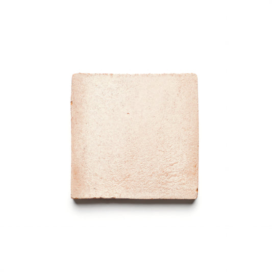 The Zia Tile 4x4 Square + Blanco is a light pink, square ceramic tile with a slightly rough texture, shown on a white background.