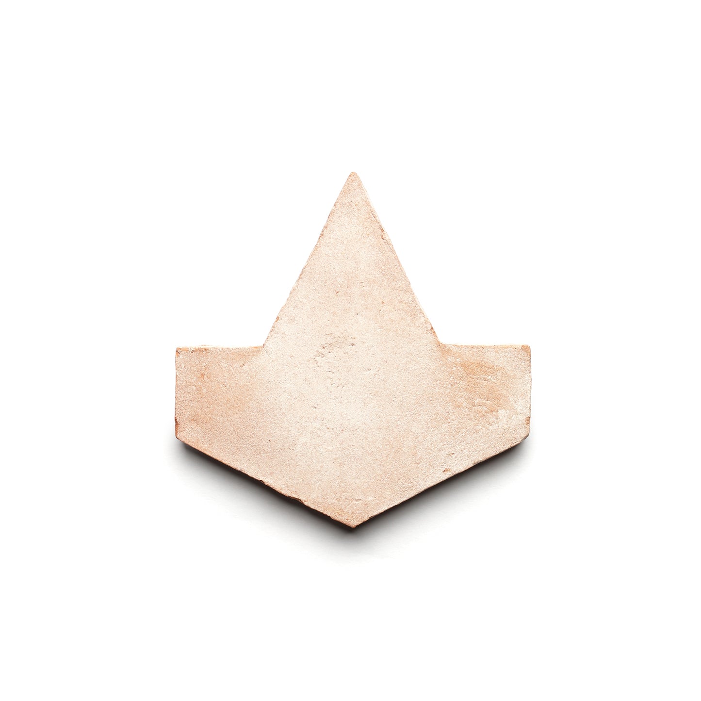Alcazar + Blanco by Zia Tile: a light beige, arrowhead-shaped ceramic tile with a textured surface, inspired by handmade Cotto and classic ceramic arts, displayed on a white background.