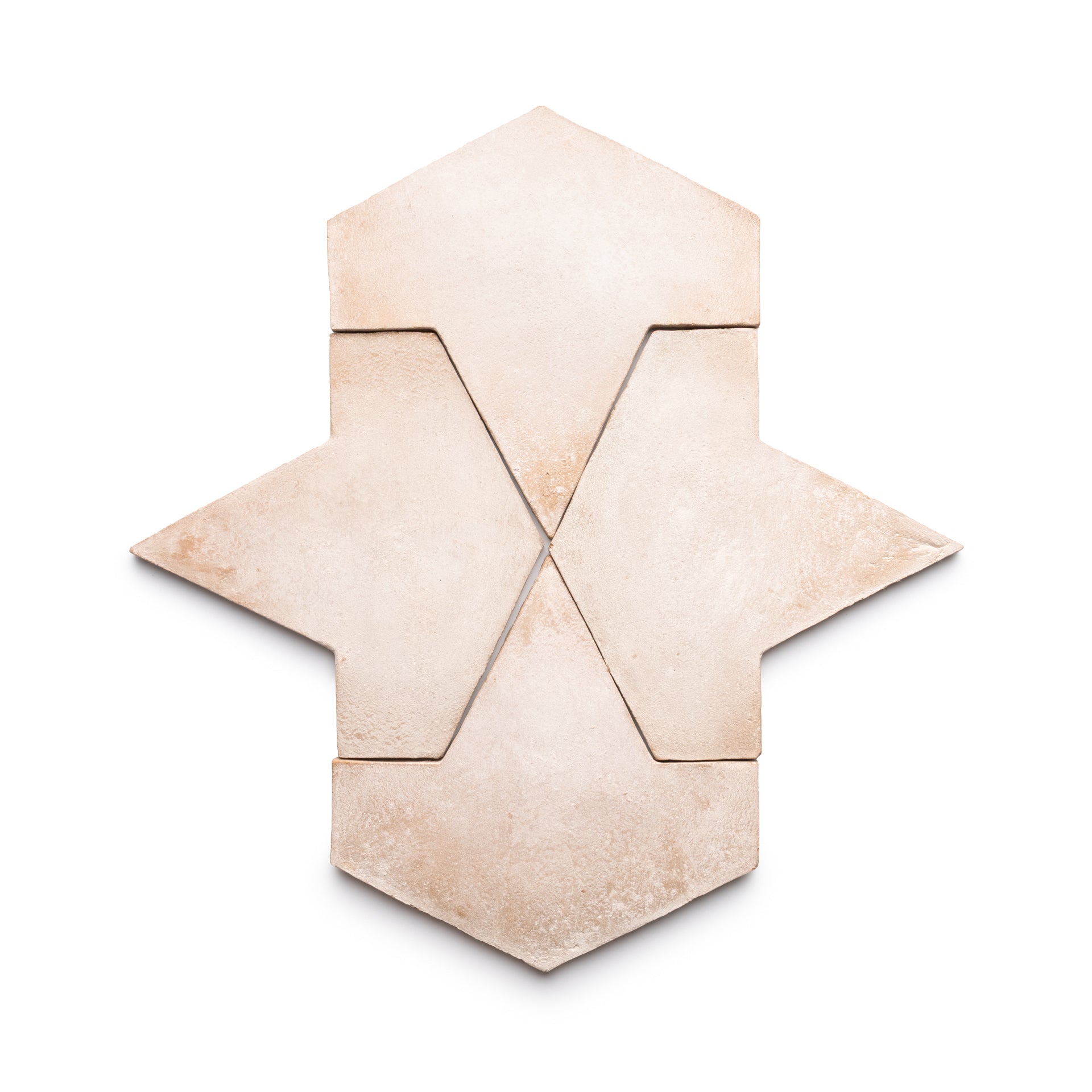 Four Big Alcazar + Blanco tiles by Zia Tile in matte beige stone are arranged to form a geometric, arrow-like pattern against a white background, with tight placement for sharp, clean lines.