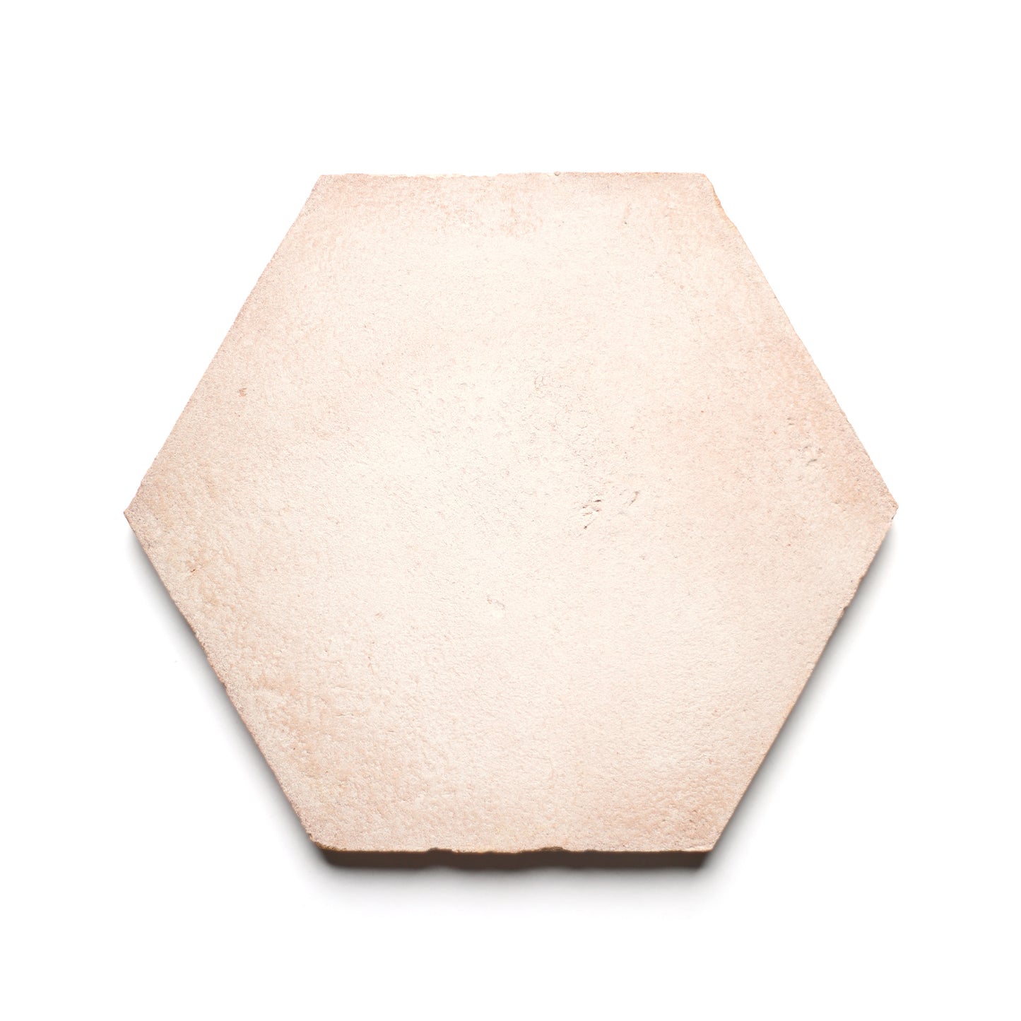 The 8x9 Hex + Blanco tile by Zia Tile is a single, light beige hexagonal piece with a slightly rough, handmade Cotto ceramic texture, shown on a white background.