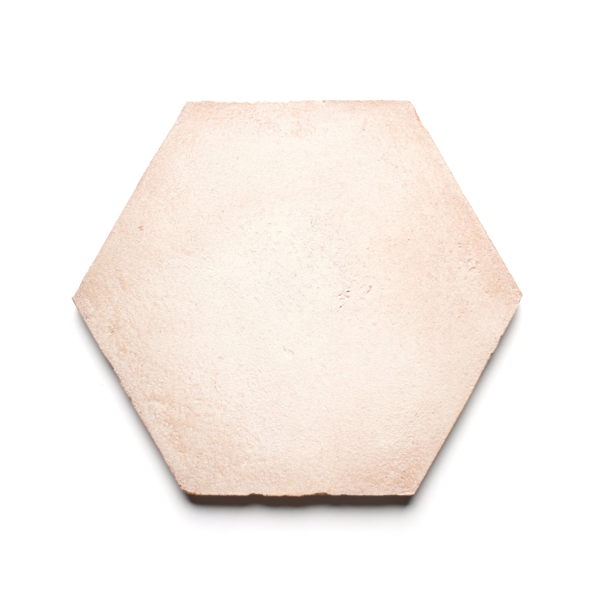 The 8x9 Hex + Blanco tile by Zia Tile is a single, light beige hexagonal piece with a slightly rough, handmade Cotto ceramic texture, shown on a white background.
