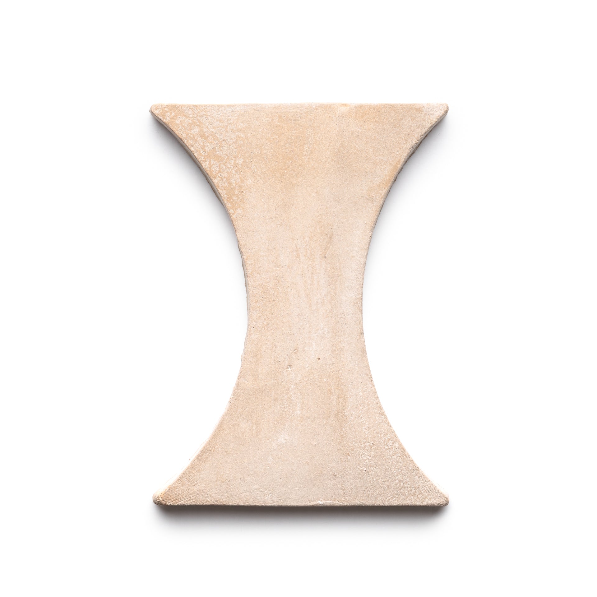 The Oaxaca + Blanco tile by Zia Tile features a beige, hourglass-shaped ceramic design with a matte finish, shown on a white background.