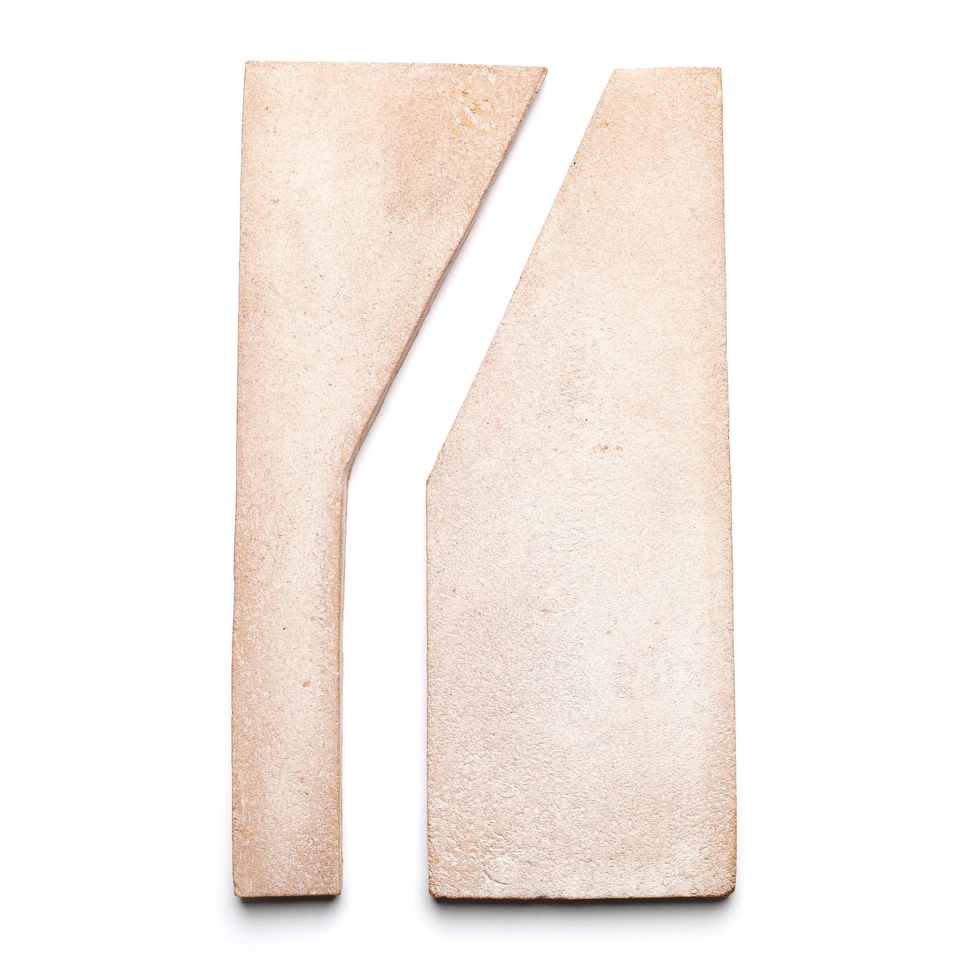 Two beige Zocalo and white Blanco handmade ceramic tiles from Zia Tile, placed side by side with a diagonal cut, create an abstract geometric composition on a white background.