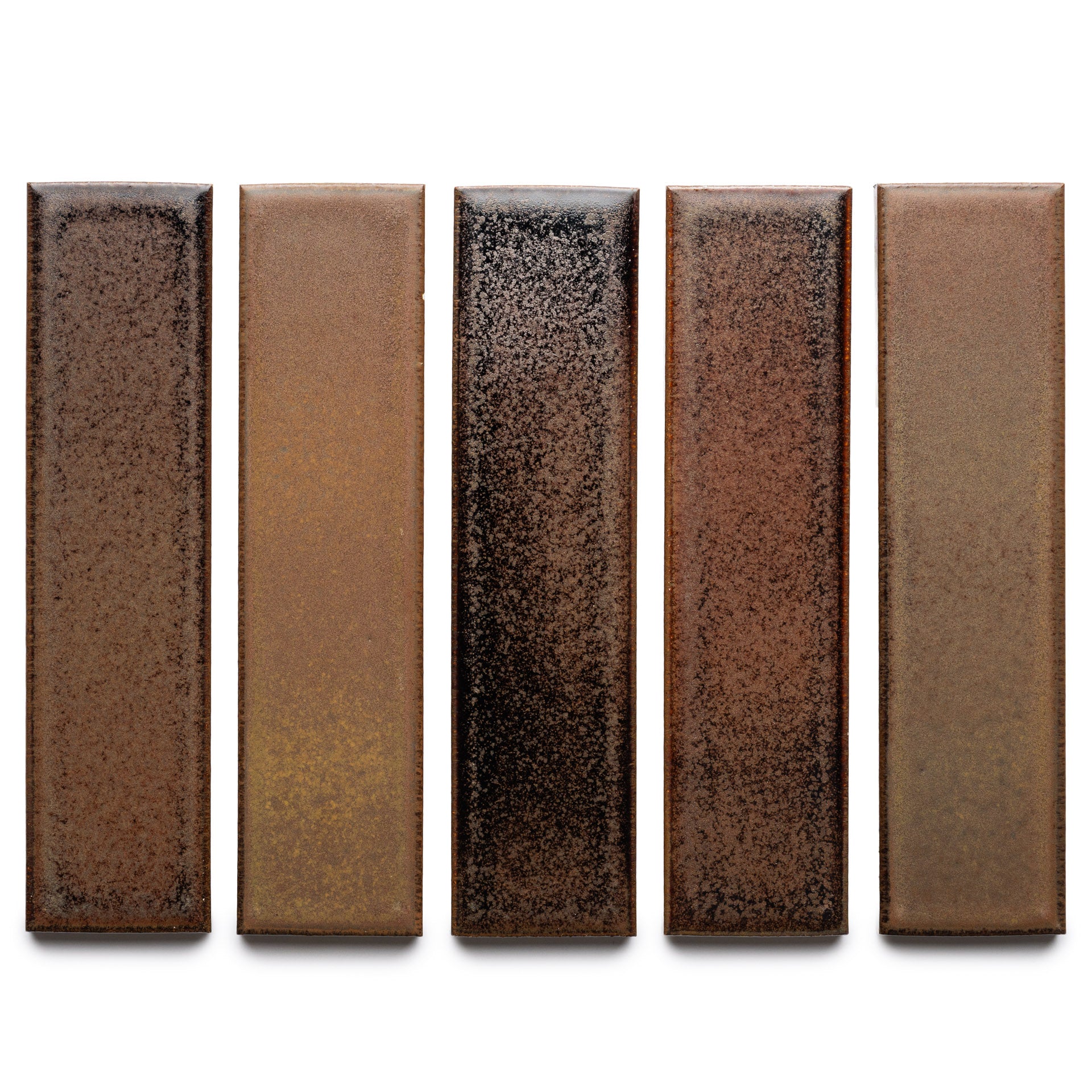 Five Buckeye + Flat ceramic tiles by Zia Tile are arranged vertically, each displaying a unique earthy brown gradient with black speckles on a white background.