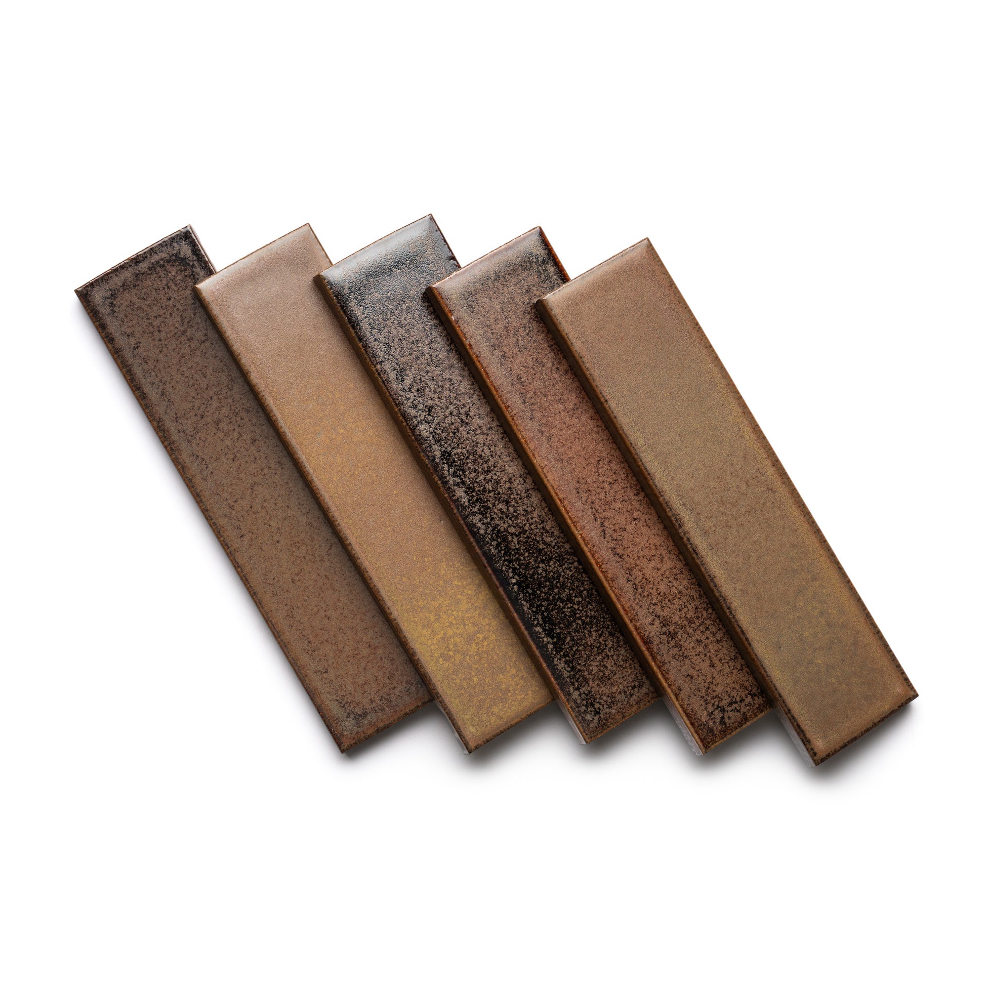 Five rectangular Buckeye + Flat ceramic tiles by Zia Tile, in shades of brown and tan with a speckled, textured finish, are arranged in a staggered pattern on a white background.