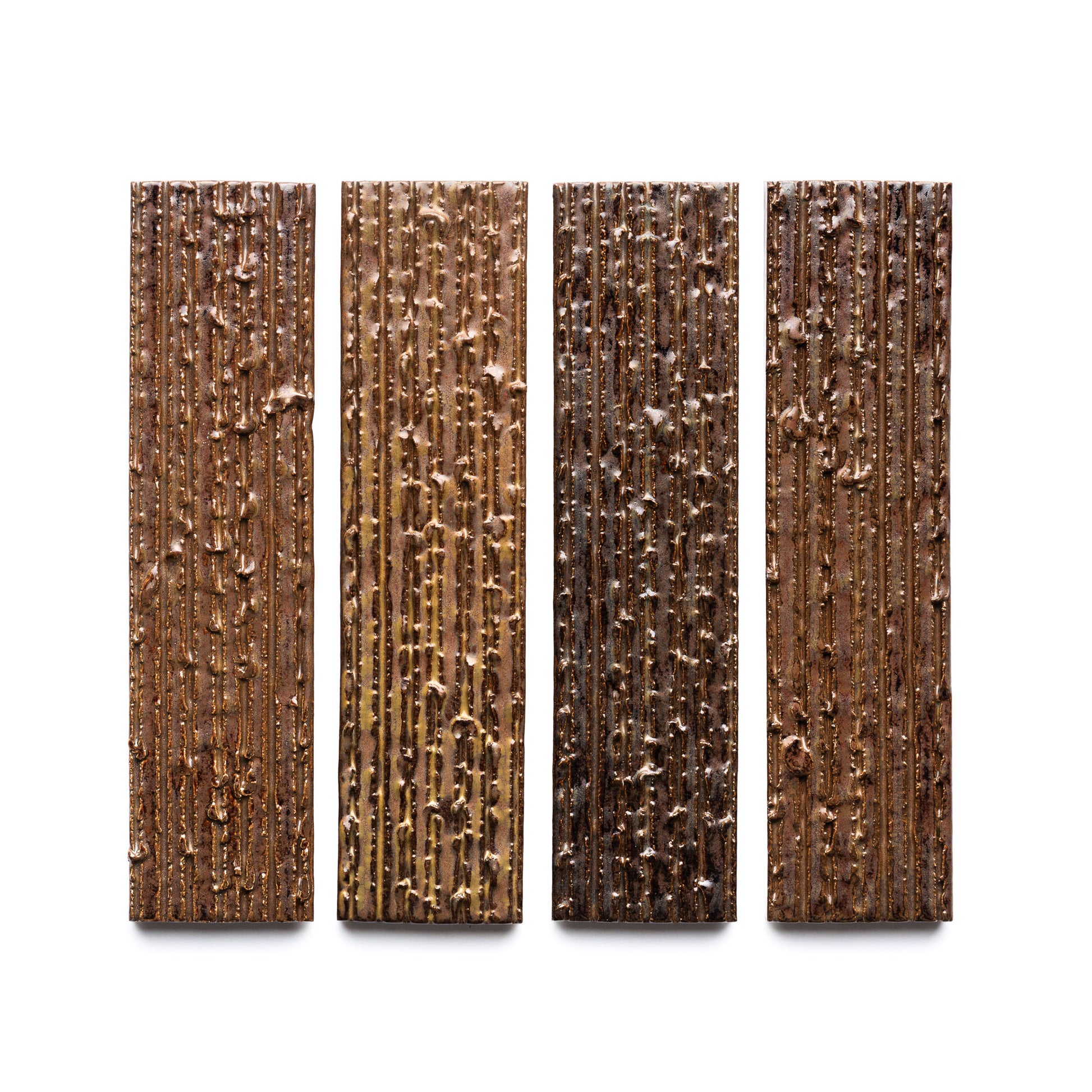 Four Buckeye + Furrowed bars by Zia Tile, each with vertical textures and uneven surfaces, are shown side by side against a white background. The shades vary from light to dark brown.