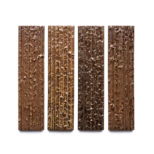 Four Buckeye + Furrowed bars by Zia Tile, each with vertical textures and uneven surfaces, are shown side by side against a white background. The shades vary from light to dark brown.