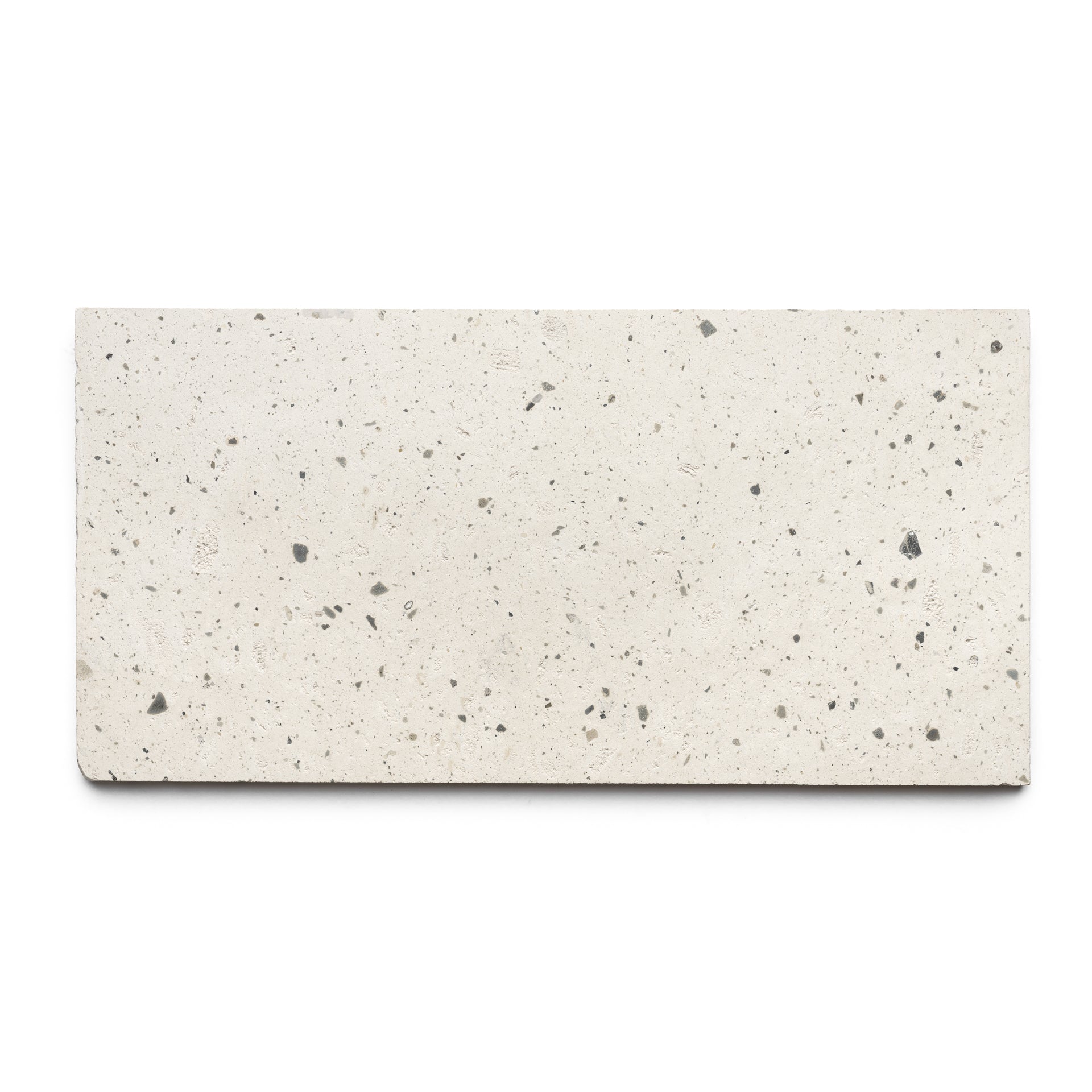 The Caldera 12x24 by Zia Tile is a handmade rectangular off-white terrazzo tile with small to medium gray and black speckles, shown on a plain white background.