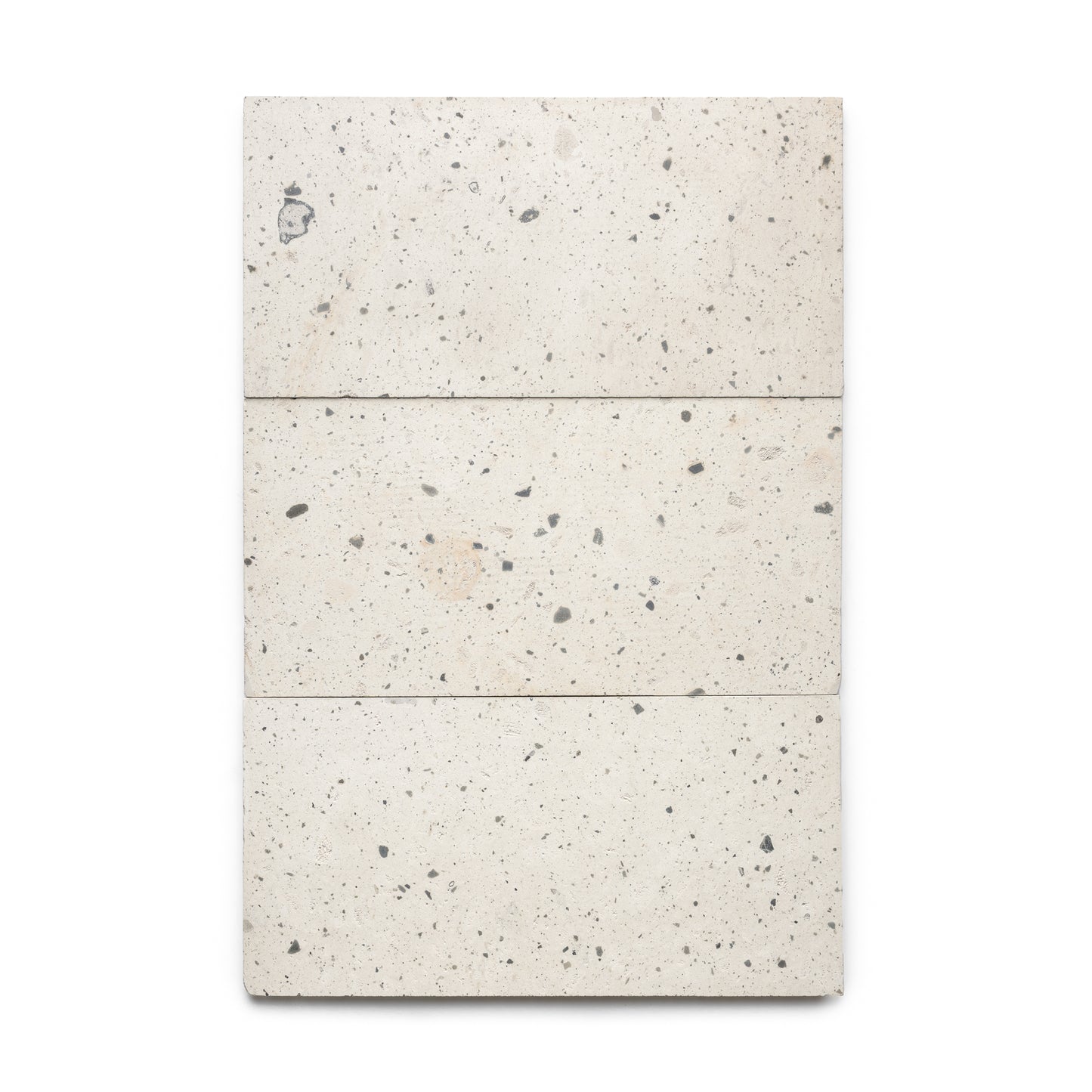 Three Caldera 12x24 tiles by Zia Tile, rectangular and speckled in off-white with gray and beige spots, are arranged vertically to create a neat panel on a plain white background.
