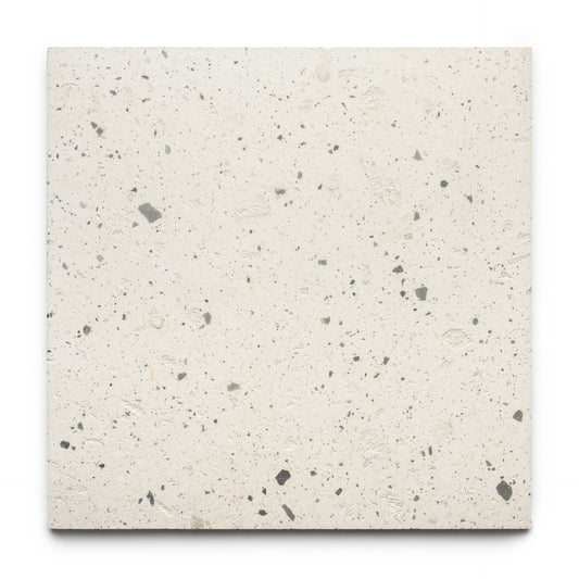 The Caldera 24x24 tile by Zia Tile is a square, off-white terrazzo tile with small, irregular gray and beige stone chips throughout, displayed on a plain white background.