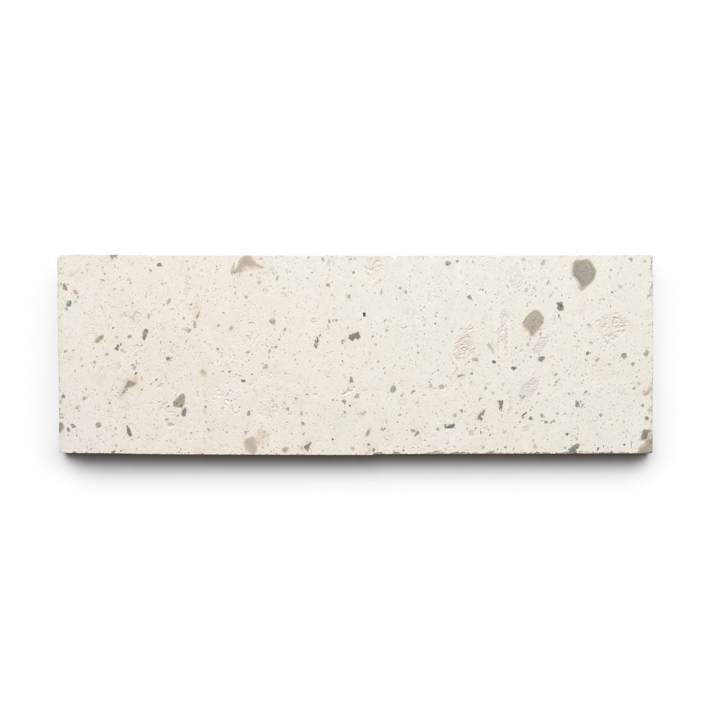 The Zia Tile Caldera 4x12 is a rectangular, off-white tile featuring small gray speckles and a rough, textured surface, shown against a white background.