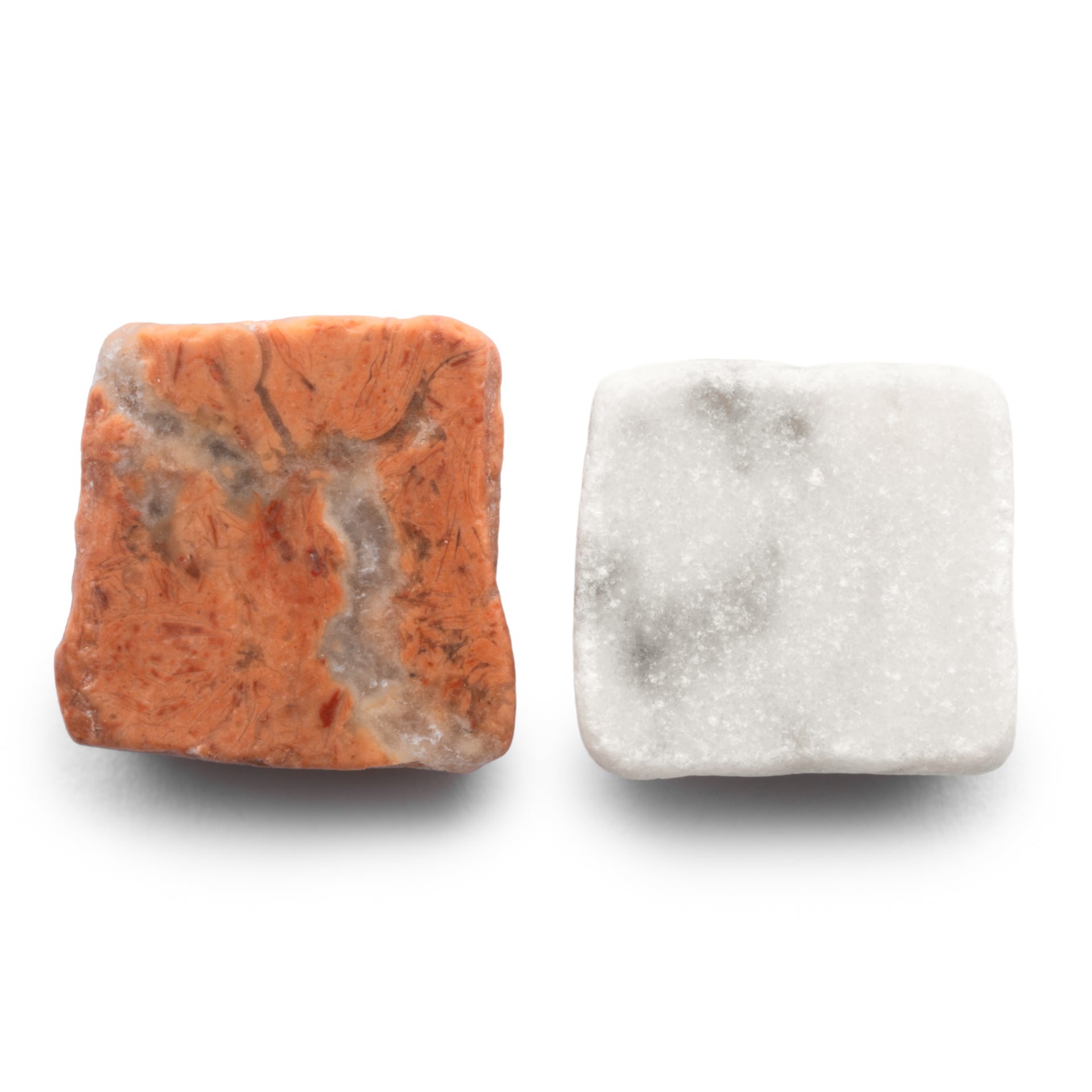 Check in Carrara + Rosso Alicante by Zia Tile: two square tiles side by side—one orange with gray veins, the other white with light gray specks—both featuring a smooth, slightly polished finish.