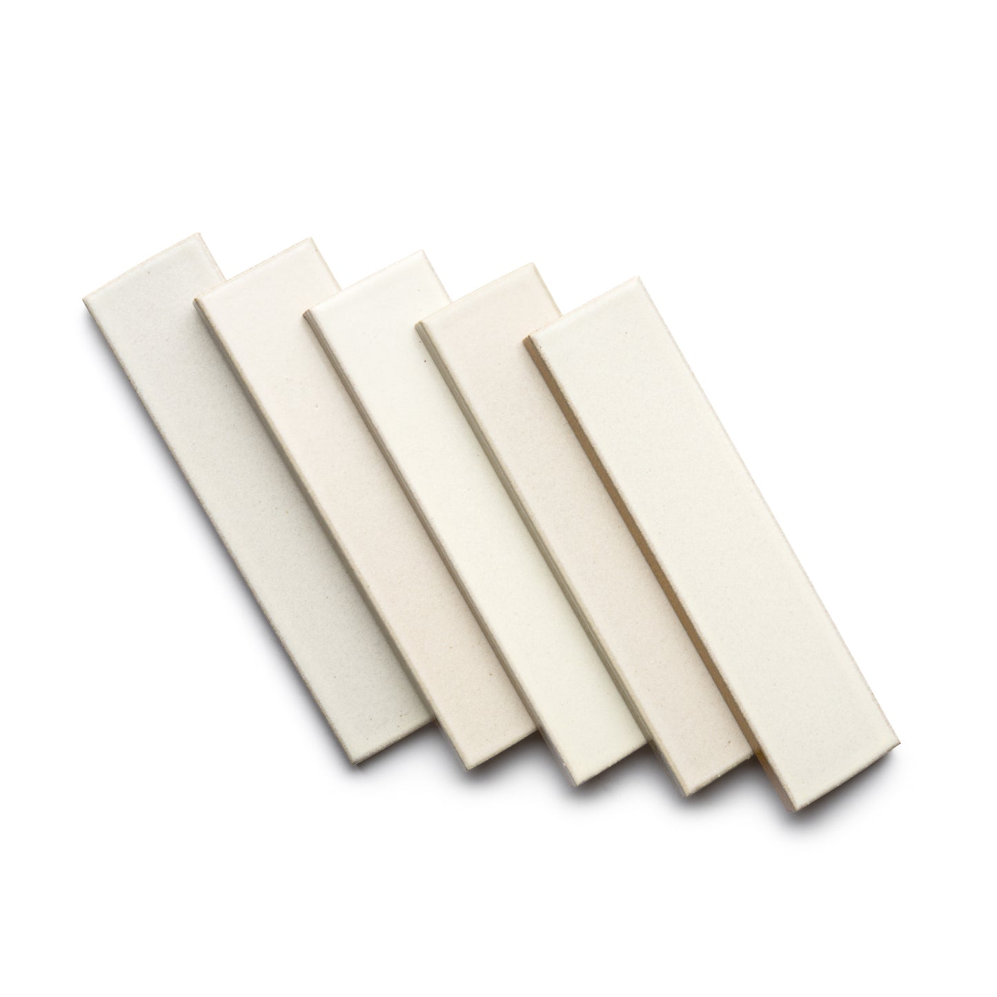 Five Feather + Flat tiles by Zia Tile in cream and off-white are arranged in a slightly fanned-out pattern on a white background.