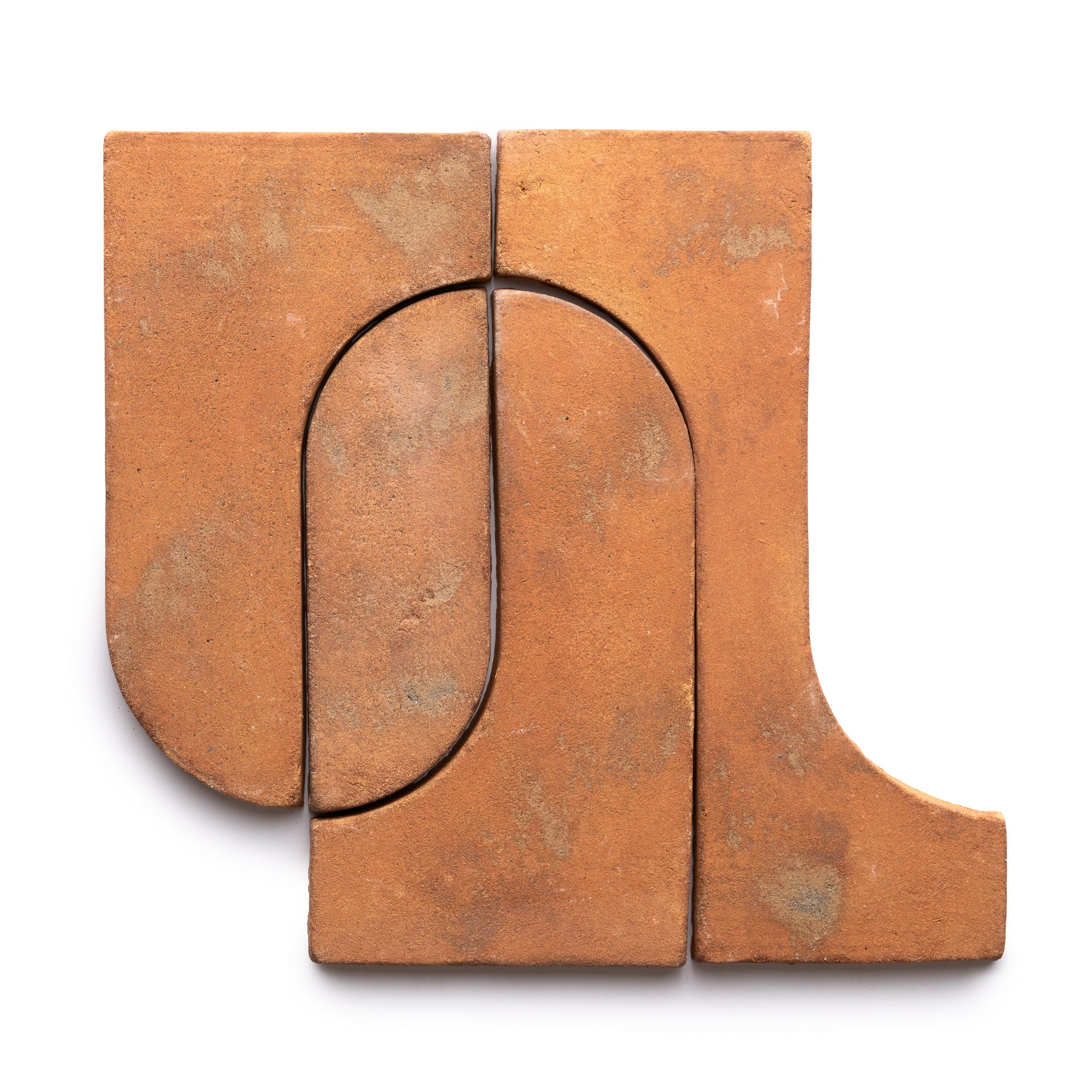 Durango + Fired Earth by Zia Tile: four interlocking terracotta tiles feature geometric shapes and a natural, slightly textured finish, forming an abstract design on a white background.