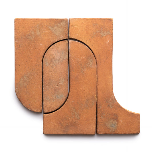 Durango + Fired Earth by Zia Tile: four interlocking terracotta tiles feature geometric shapes and a natural, slightly textured finish, forming an abstract design on a white background.