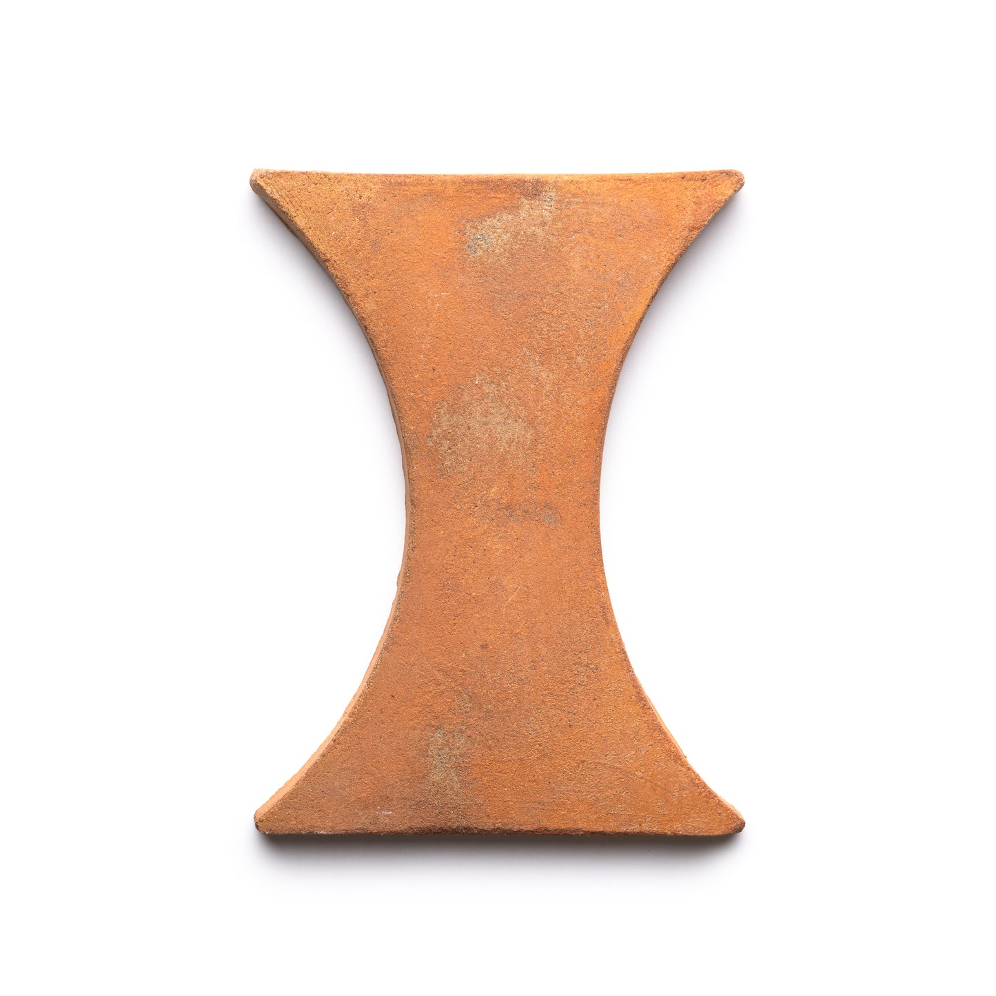 The Oaxaca + Fired Earth by Zia Tile is a reddish-brown, hourglass-shaped clay tile with flat surfaces and a slightly rough texture, shown on a white background.