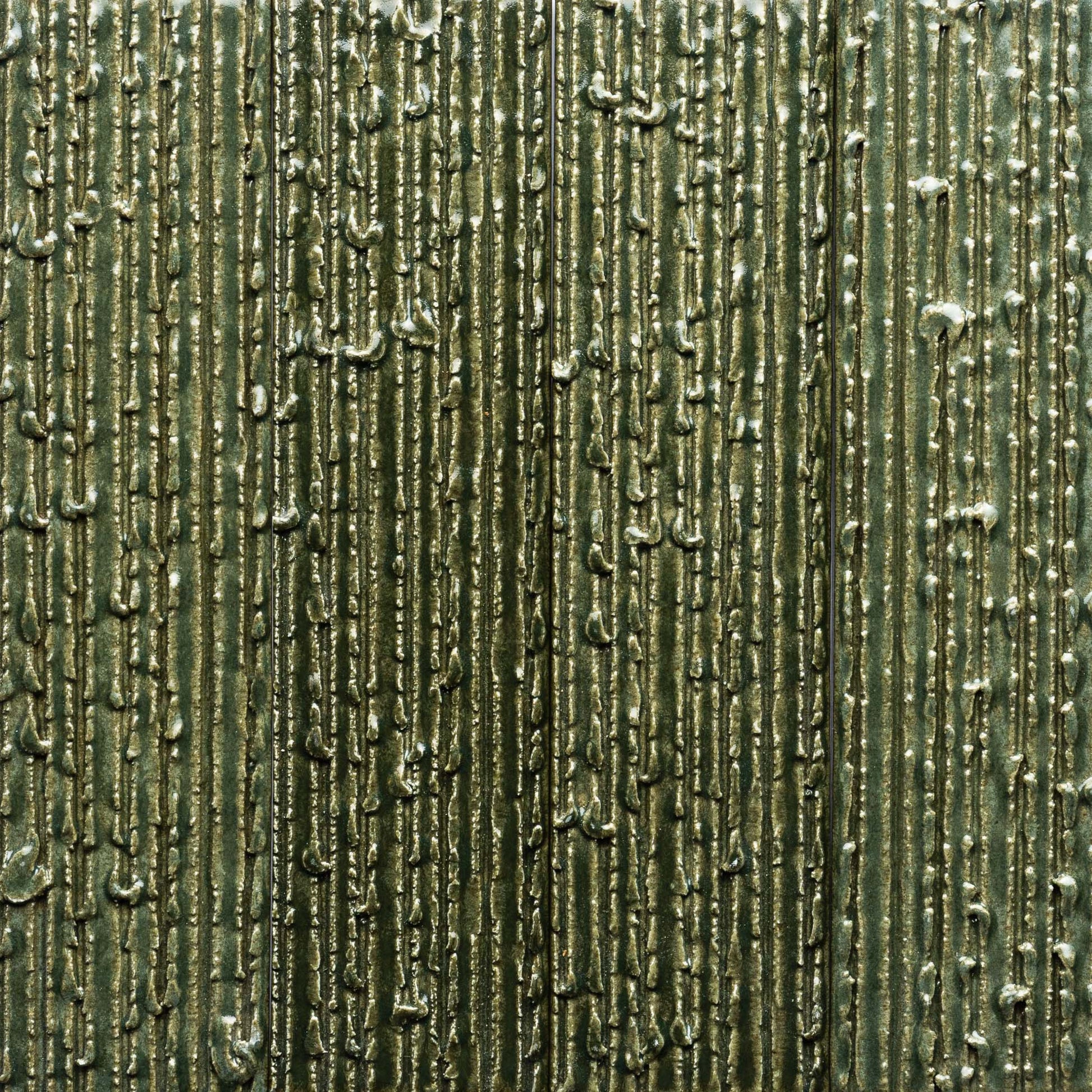 Close-up of Zia Tile’s Frogtown + Furrowed: a textured metallic green tile with vertical, irregular raised lines and small bumps, forming an abstract, industrial pattern with shiny, reflective areas.