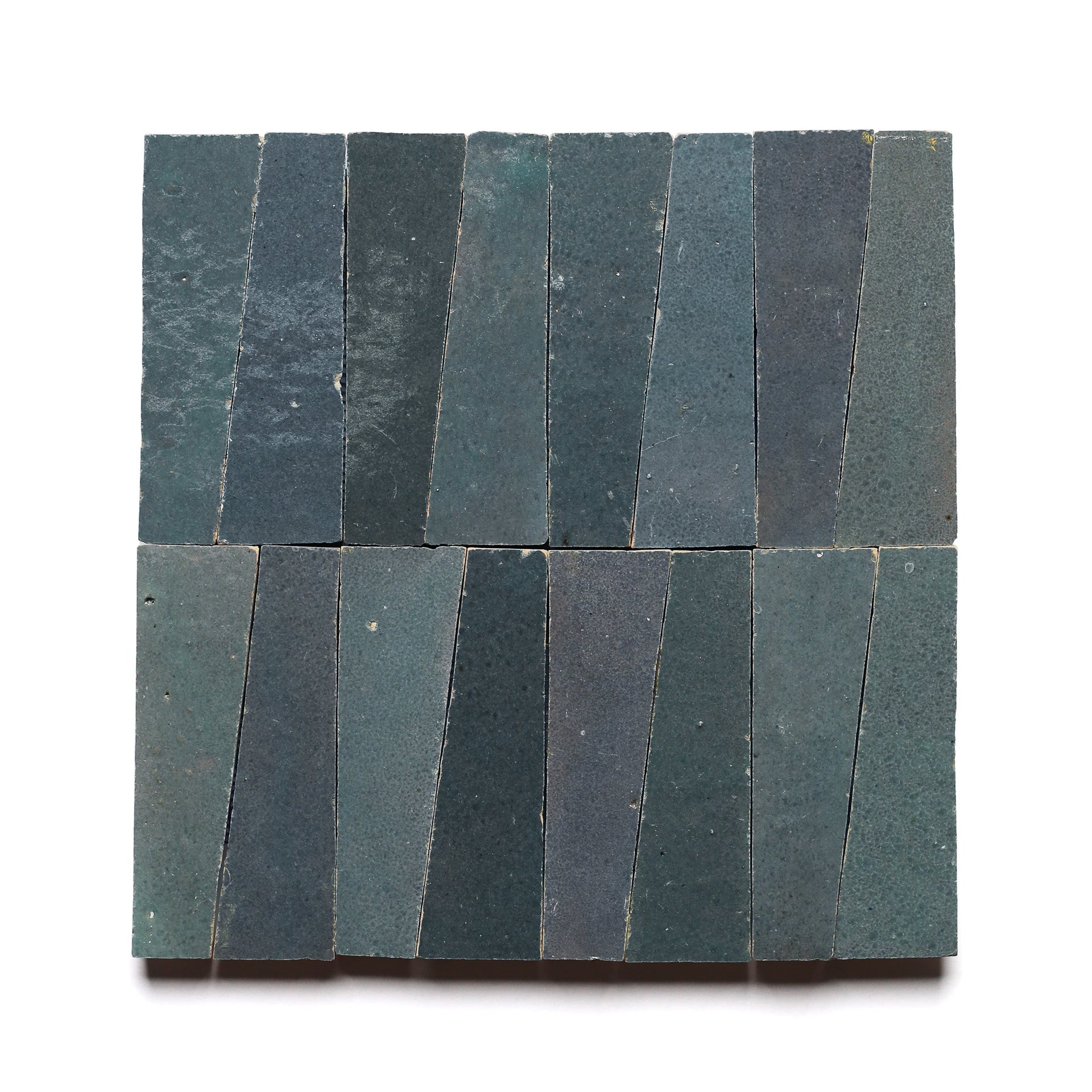 Sixteen Graphite Grey Trapezoid tiles, each with subtle texture variation, are arranged in a square grid of four vertical rows on a white background.