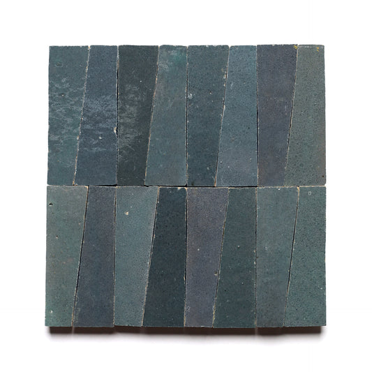 Sixteen Graphite Grey Trapezoid tiles, each with subtle texture variation, are arranged in a square grid of four vertical rows on a white background.