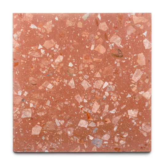 The Guava 24x24 by Zia Tile is a square, terracotta-colored terrazzo tile with irregular white, pink, and reddish stone chips embedded throughout for a speckled look on a smooth handmade surface.