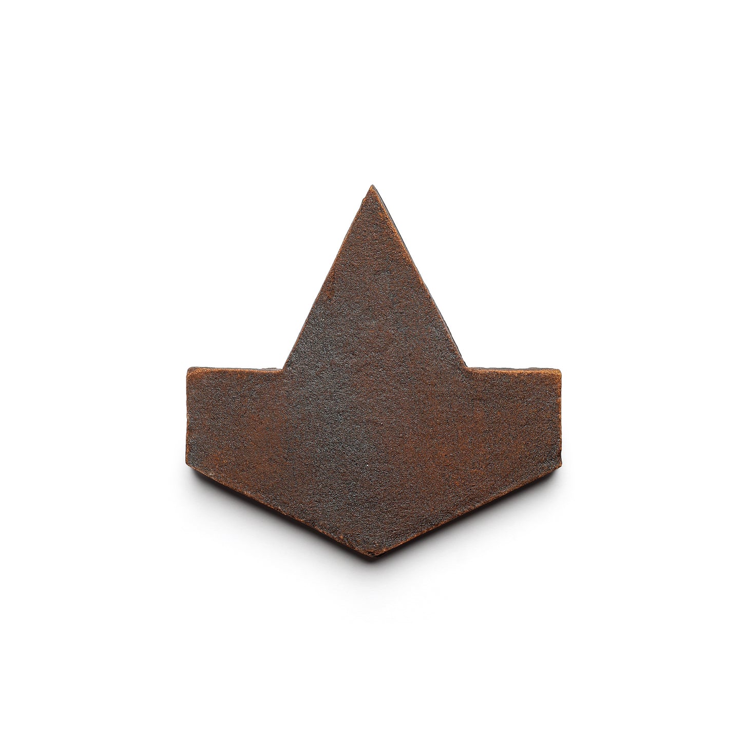 A flat, rusted metal object shaped like an upward arrowhead, inspired by handmade Cotto from San Miguel de Allende, is featured as Alcazar + Madera by Zia Tile against a plain white background.