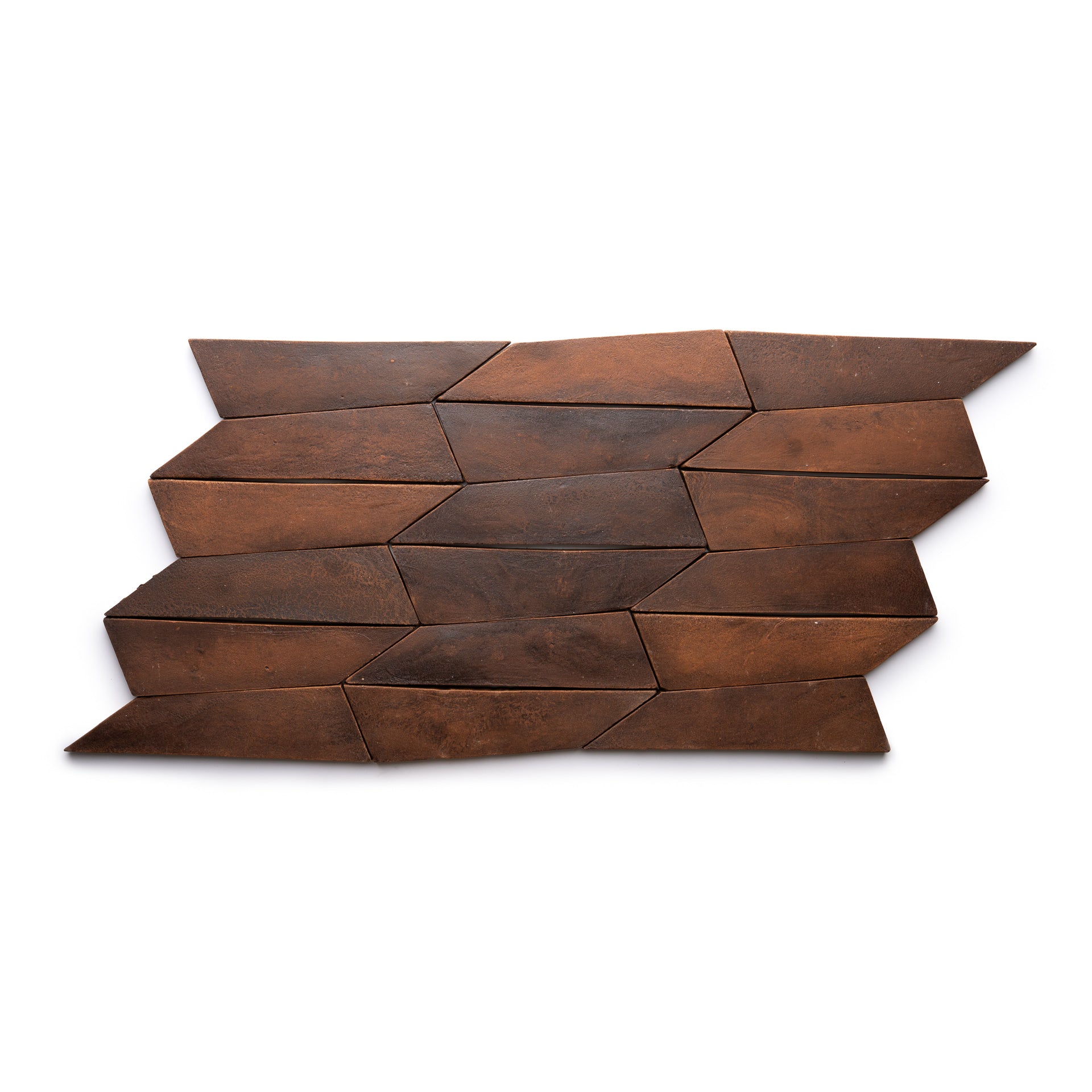 The Tornillo + Madera sample by Zia Tile features a geometric pattern of brown, arrow-shaped tiles in three offset rows, forming a dynamic zigzag design on a white background.