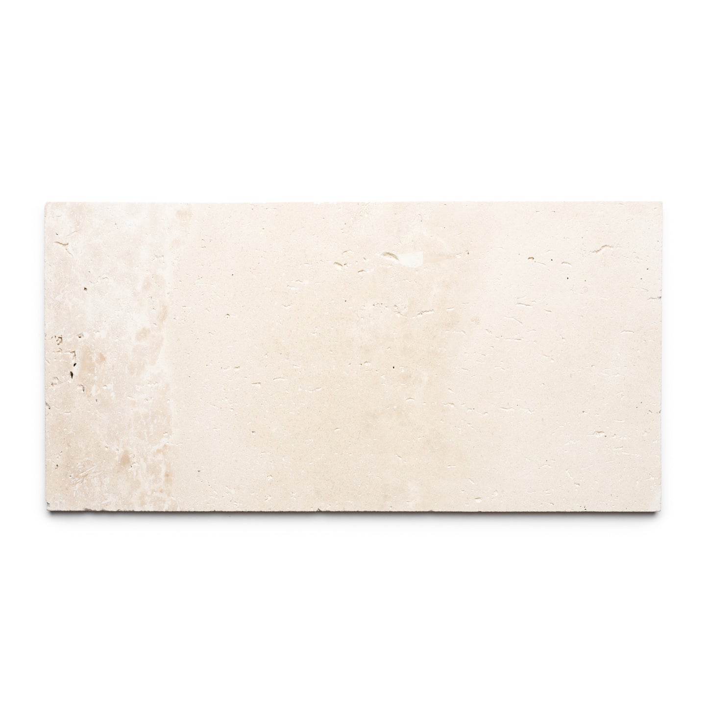 The Mesa 12x24 tile by Zia Tile is a rectangular beige Mexican Cantera stone tile with a slightly rough texture and subtle natural color variations, shown against a white background.