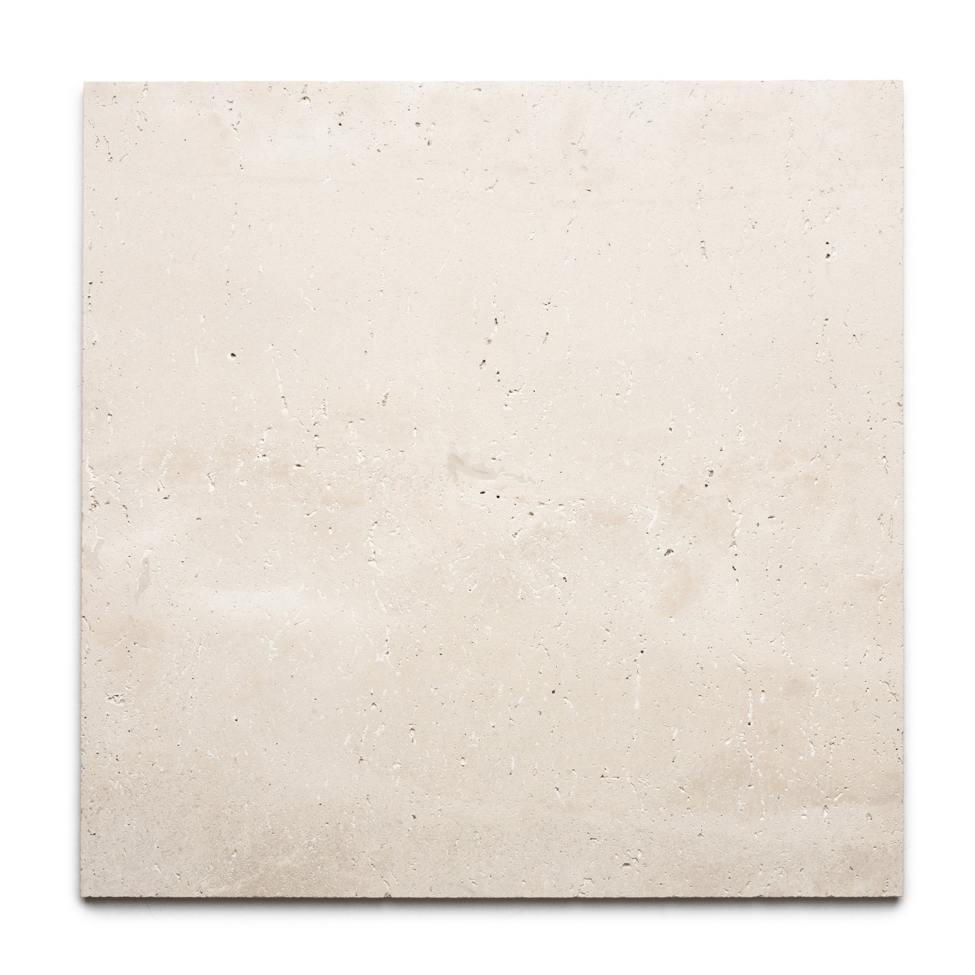 The Mesa 24x24 by Zia Tile is a rectangular slab of light beige Mexican Cantera stone tile with a smooth surface, subtle natural texture, small holes, and faint mineral patterns, displayed against a white background.