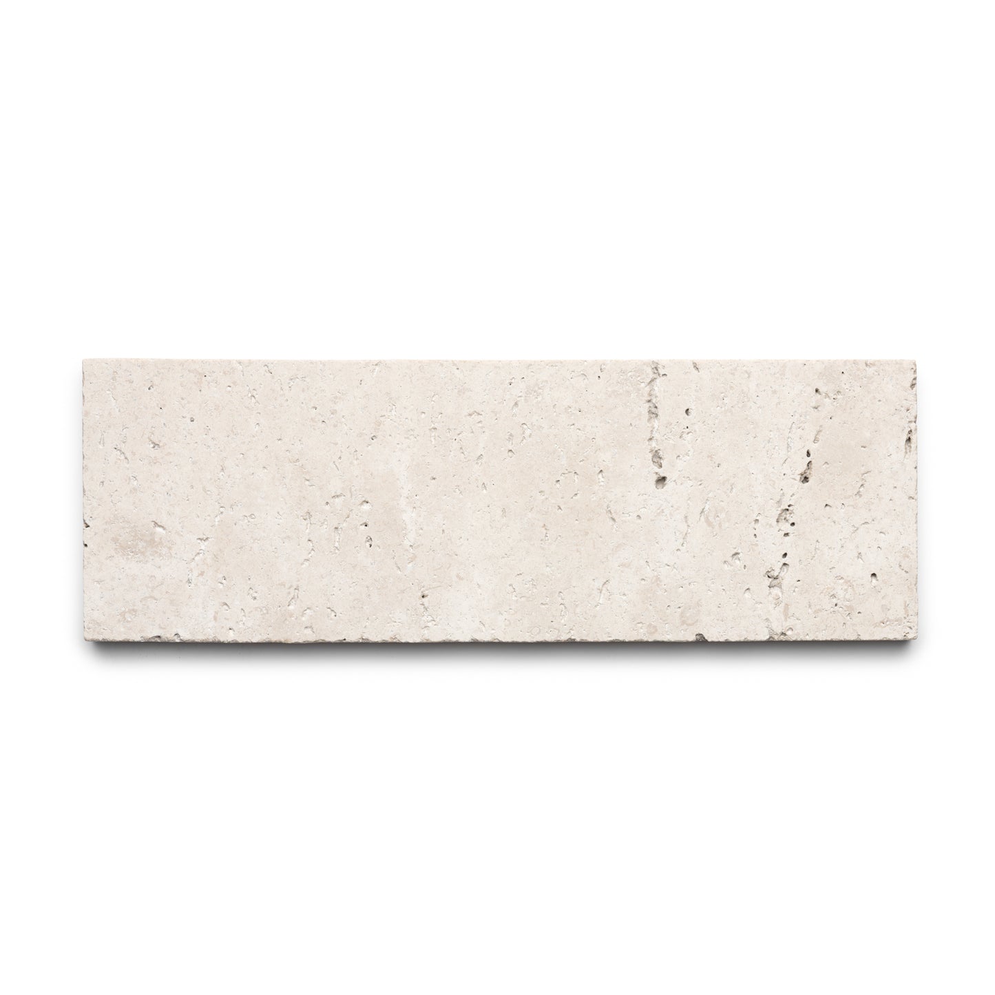 The Mesa 4x12 by Zia Tile is a rectangular beige Cantera tile, crafted from authentic volcanic stone with a smooth surface and subtle natural veining, shown on a white background.