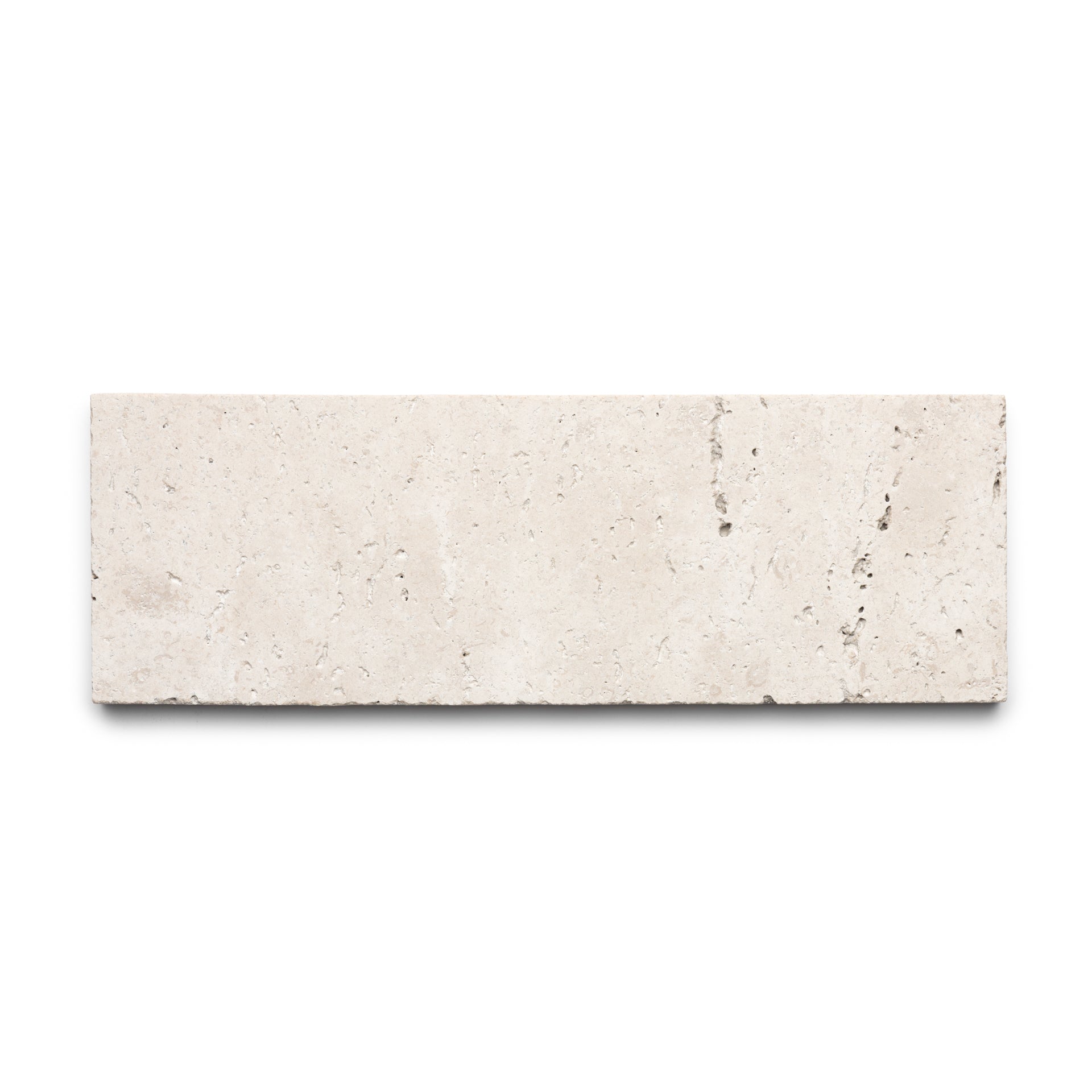 The Mesa 4x12 by Zia Tile is a rectangular beige Cantera tile, crafted from authentic volcanic stone with a smooth surface and subtle natural veining, shown on a white background.