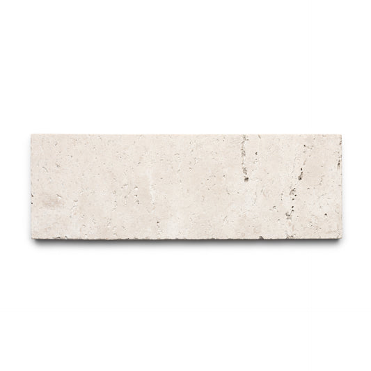 The Mesa 4x12 by Zia Tile is a rectangular beige Cantera tile, crafted from authentic volcanic stone with a smooth surface and subtle natural veining, shown on a white background.