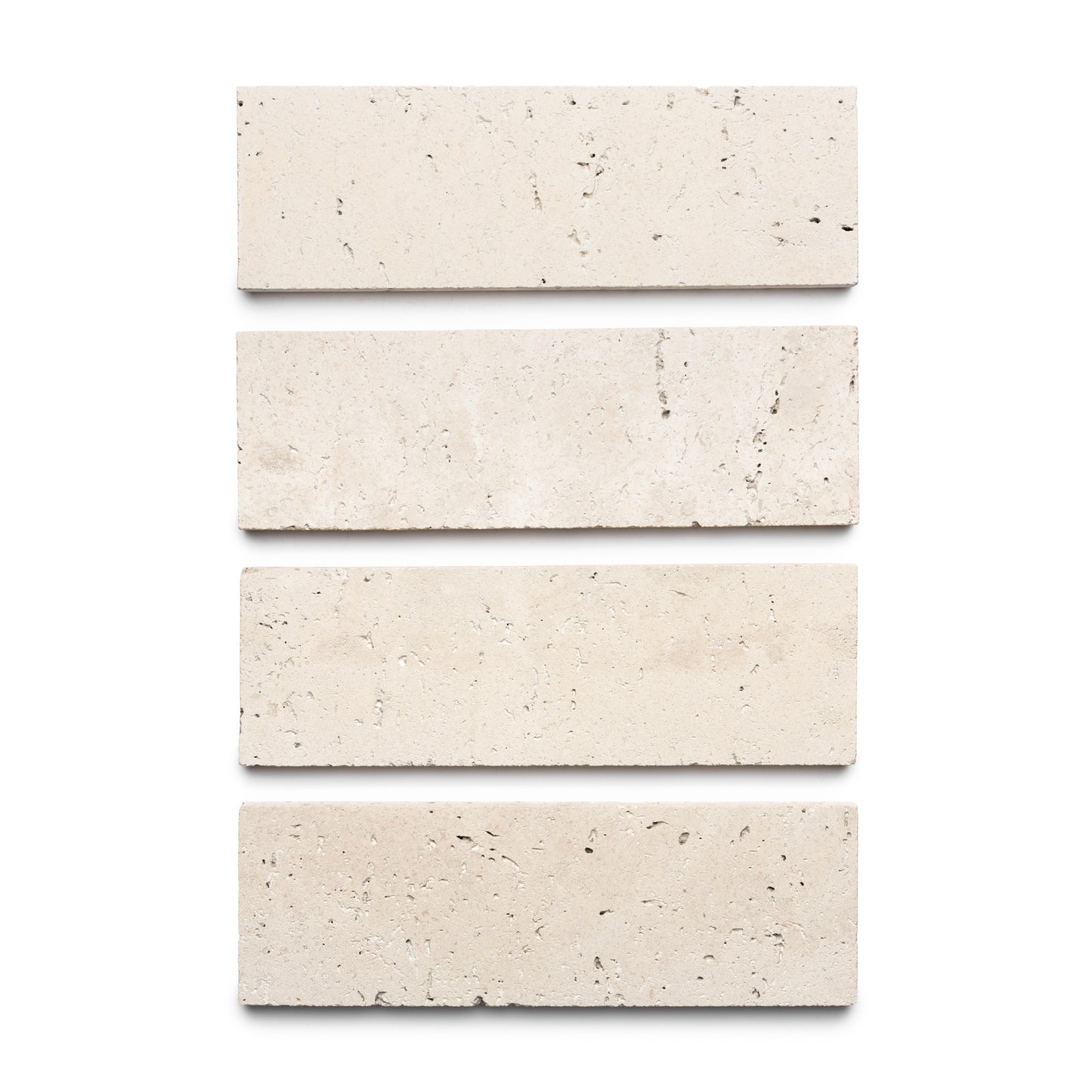 Four Mesa 4x12 rectangular light beige tiles by Zia Tile are arranged vertically on a white background, evenly spaced to display their smooth texture with small speckles and natural imperfections.