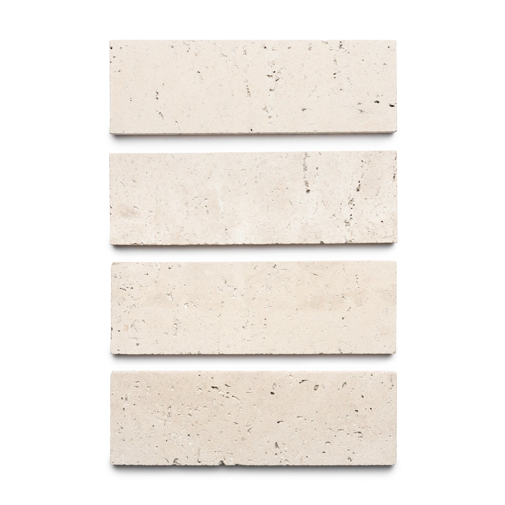 Four Mesa 4x12 rectangular light beige tiles by Zia Tile are arranged vertically on a white background, evenly spaced to display their smooth texture with small speckles and natural imperfections.