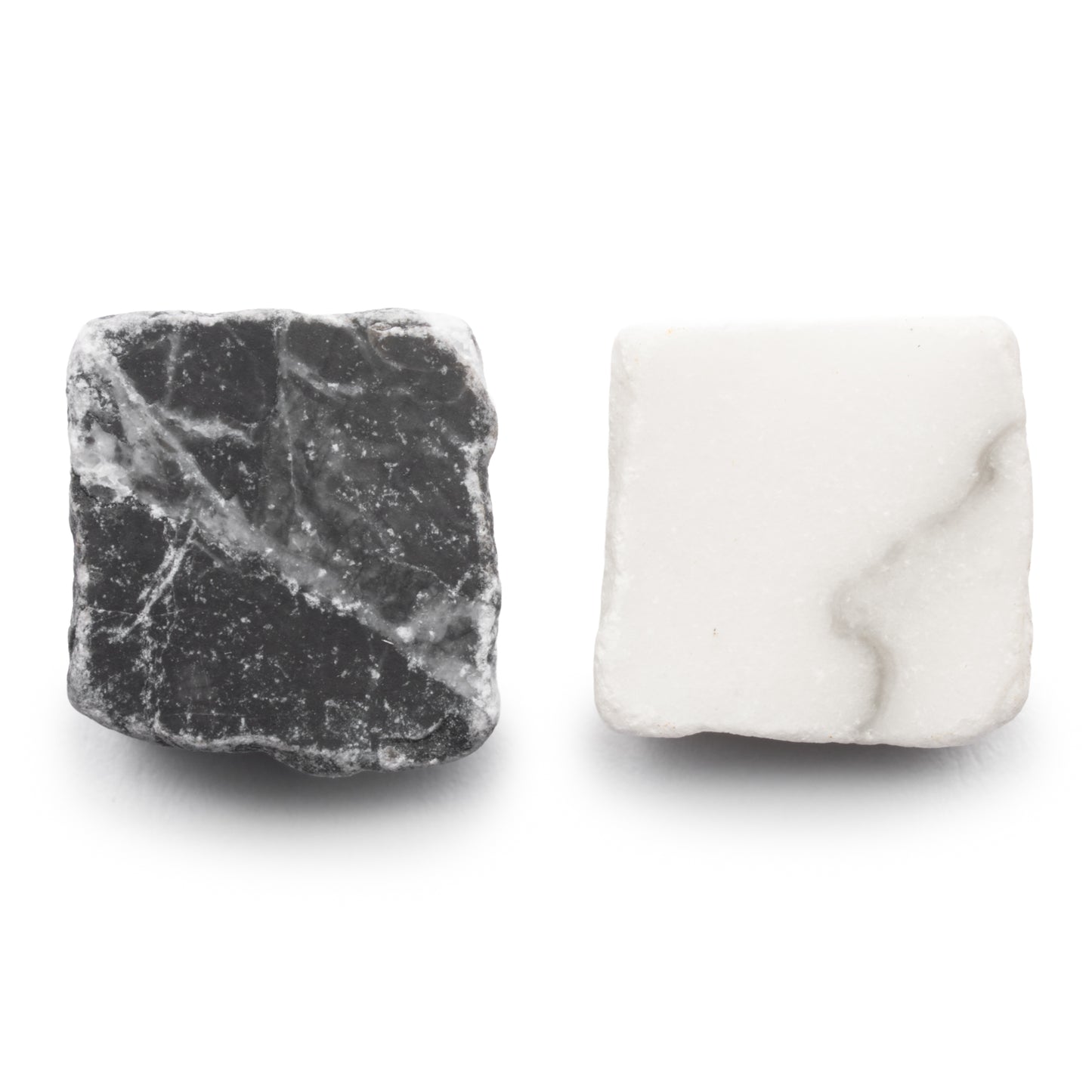 Two square tiles from Zia Tile’s Mini Check in Carrara + Grigio Carnico: one black with white veining and one white with light gray veining, both feature rough, unpolished surfaces.