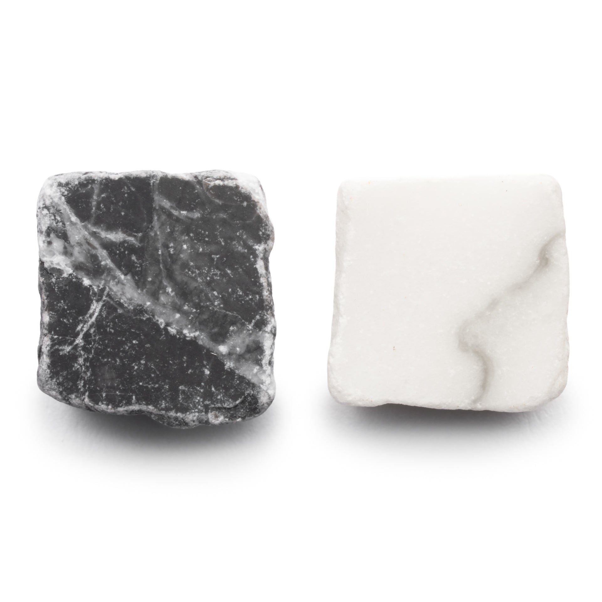 Two square tiles from Zia Tile’s Mini Check in Carrara + Grigio Carnico: one black with white veining and one white with light gray veining, both feature rough, unpolished surfaces.