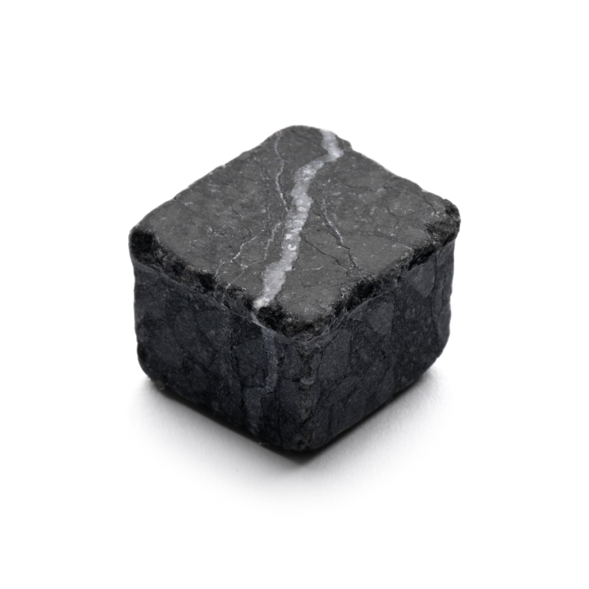 A single Mini Check in Carrara + Nero Marquina whiskey cube by Zia Tile, featuring dark gray stone with a white vein, placed on a white background.
