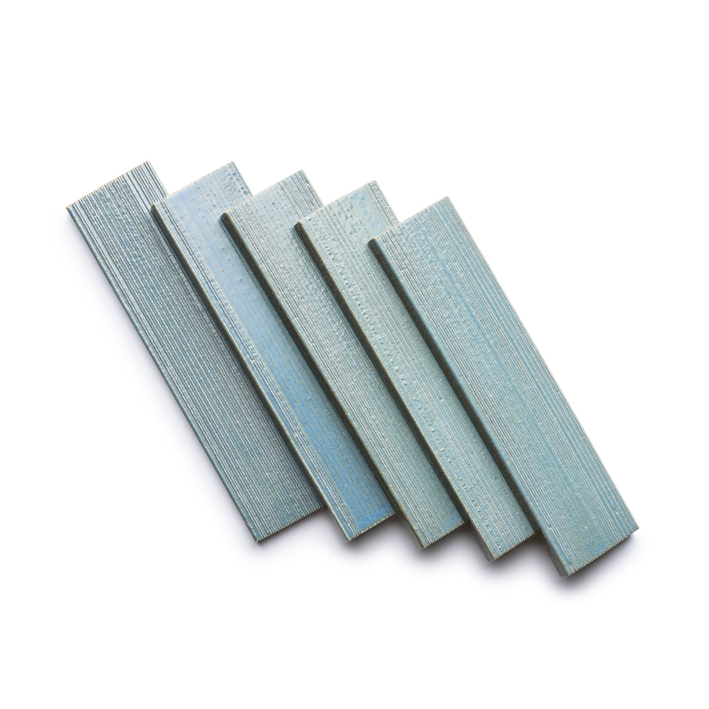 Five rectangular strips of Zia Tile's Morning Light + Etched are arranged in a slightly fanned-out pattern on a white background.