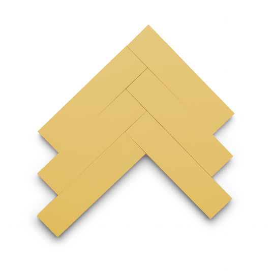 Five Mustard 2x8 tiles by Zia Tile are arranged in a herringbone pattern on a white background, with subtle shadows beneath them.