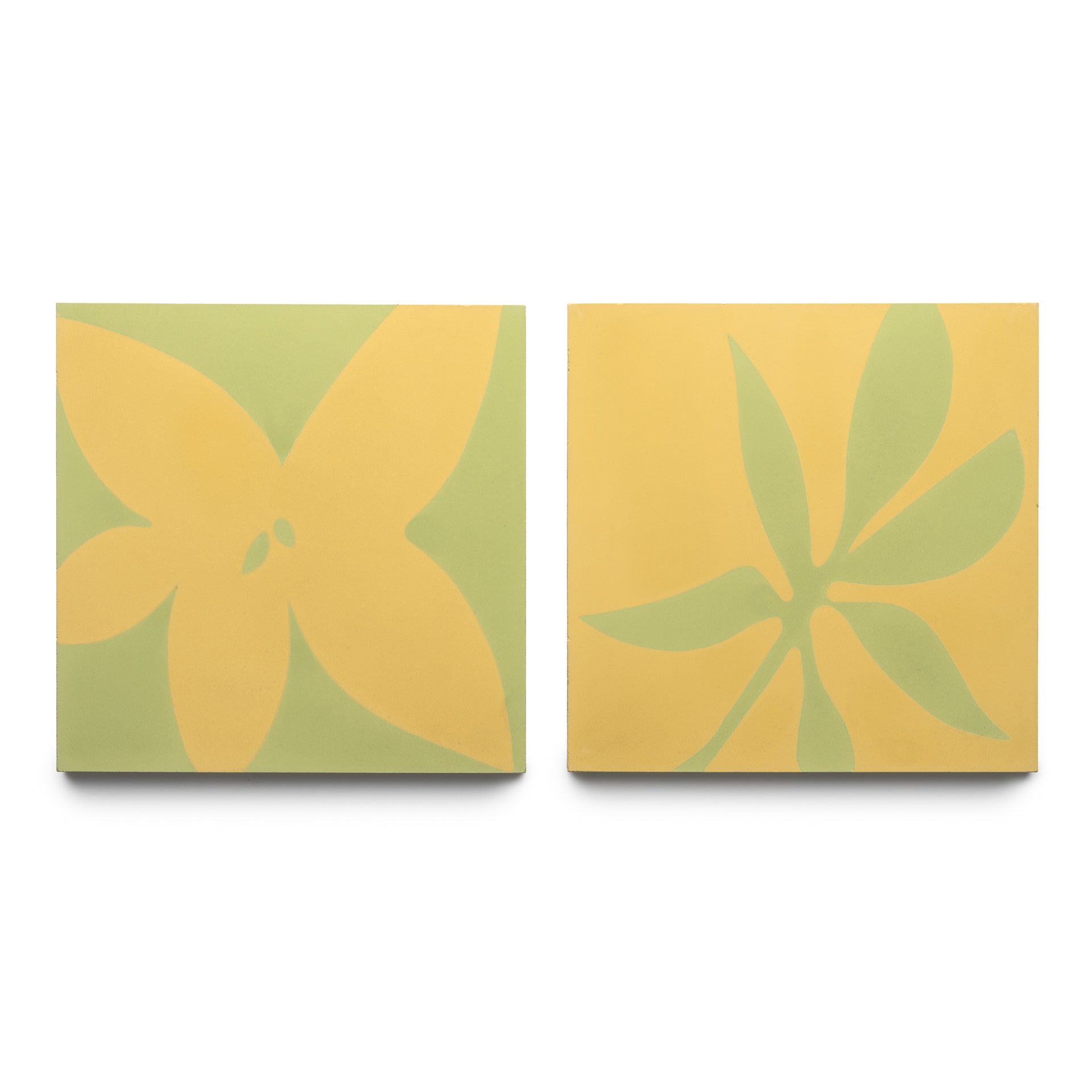 The Zia Tile Flora 8x8 Set Mustard + Lemongrass features two square tiles: one with a yellow floral motif on light green, and the other with a green leafy design on mustard yellow.