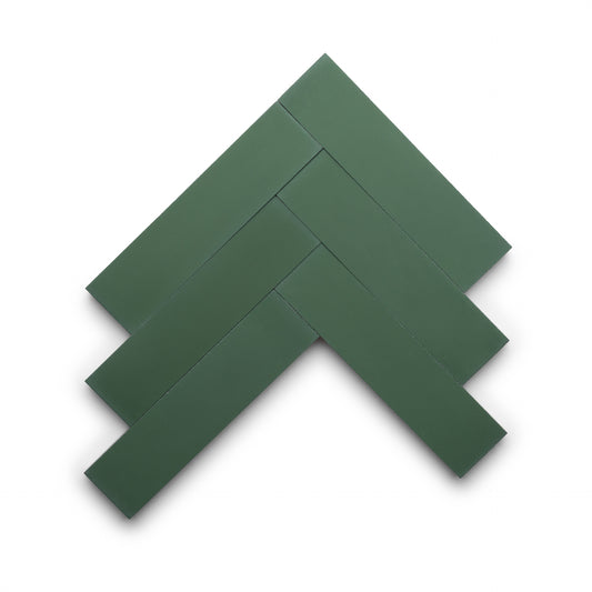 Five Noble Green 2x8 handmade tiles by Zia Tile, rectangular and dark green, are arranged in a herringbone pattern on a white background.