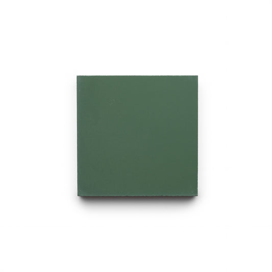 A Zia Tile Noble Green 4x4 cement tile, in a plain dark green, is centered on a white background with a soft shadow beneath and to the left.
