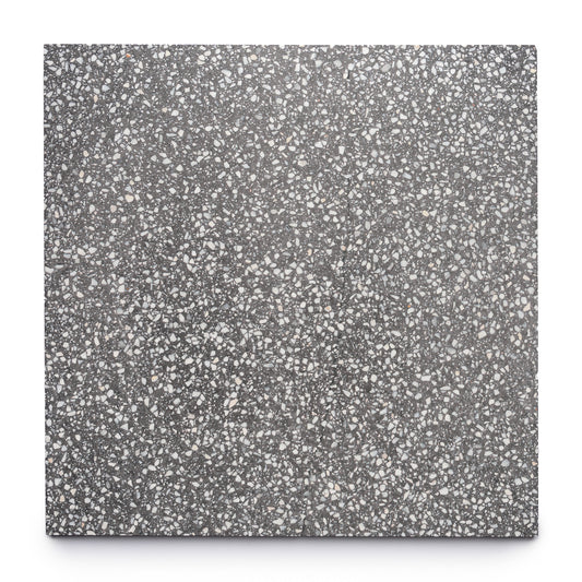 The Oscar 24x24 tile by Zia Tile is a handmade square terrazzo tile featuring a dark gray base with speckled white and light gray stone chips, shown here against a plain white background.