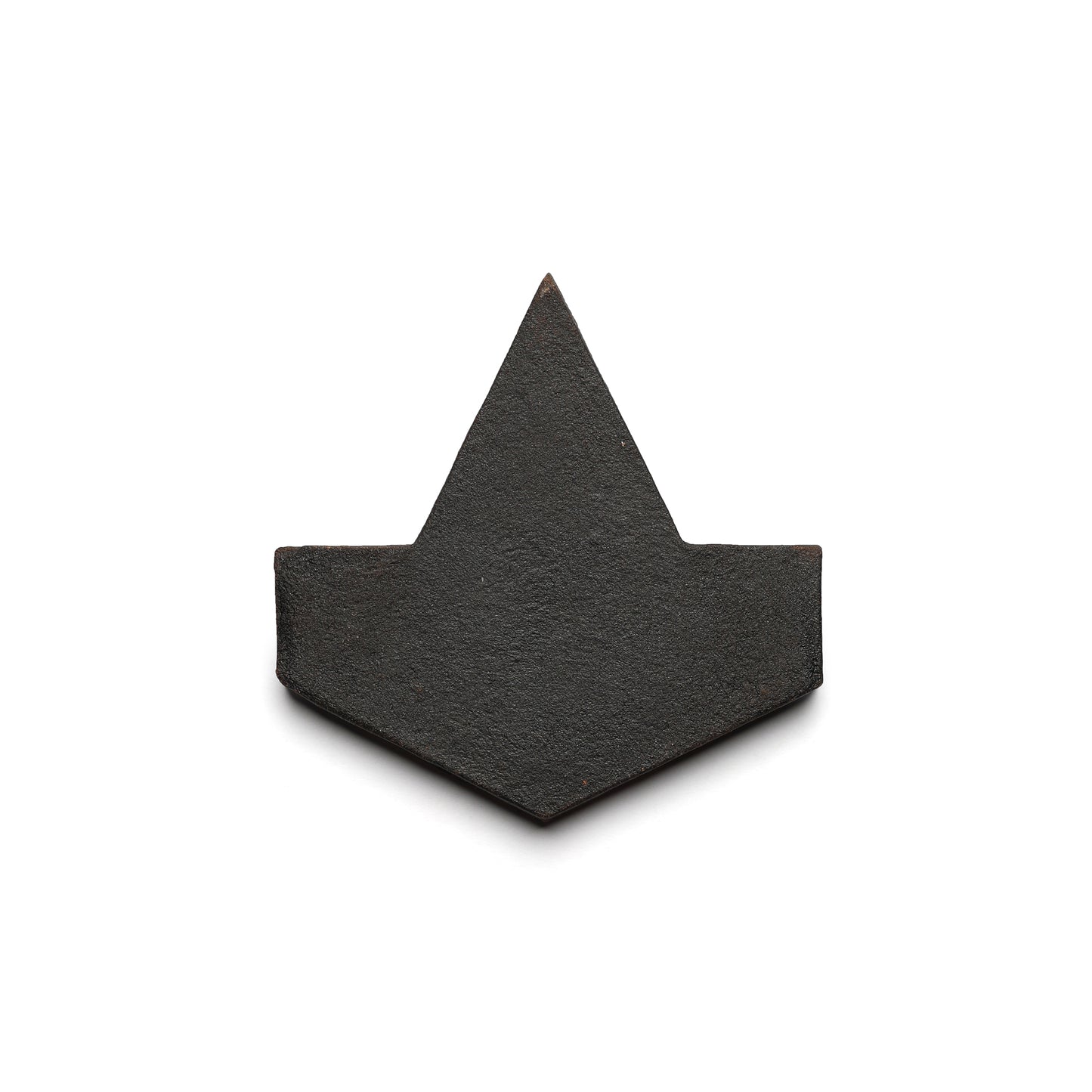 The Alcazar + Oscura by Zia Tile is a sleek black geometric tile with a central triangular peak and angled sides, inspired by minimalist paper boats and modern ceramic terra cotta design.