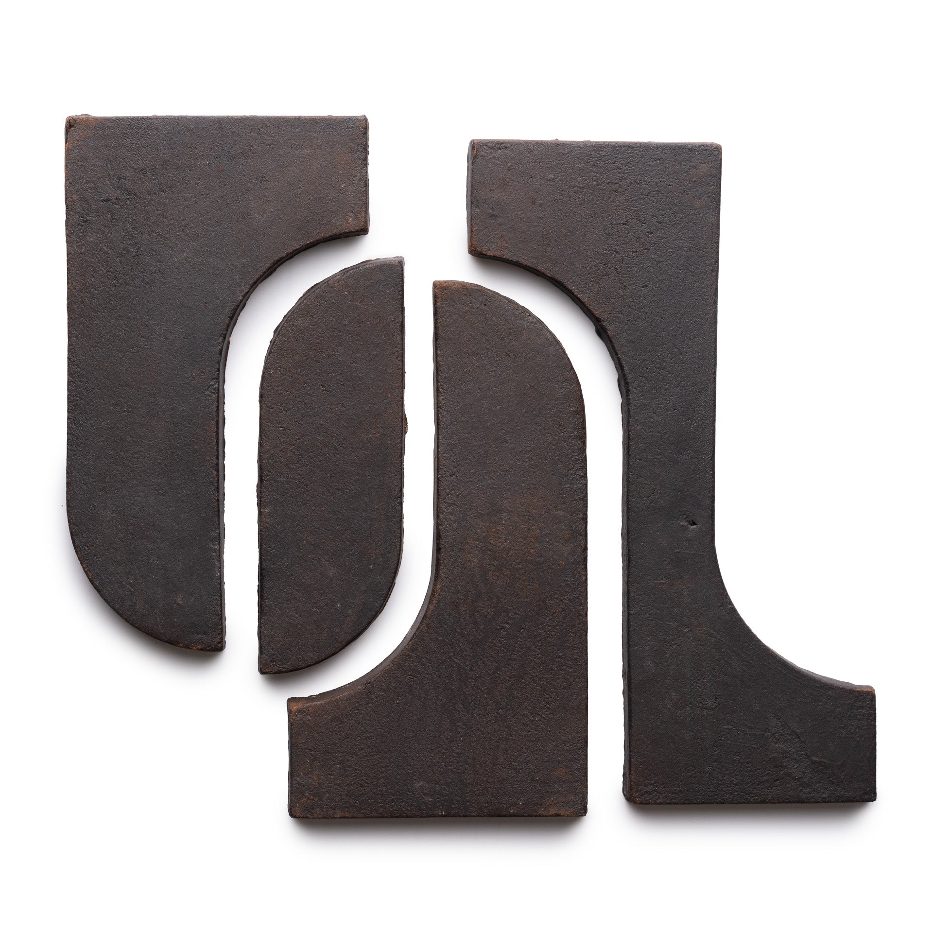 Four Durango + Oscura ceramic tiles by Zia Tile are arranged on a white background, forming an abstract pattern with curved and straight edges facing each other.