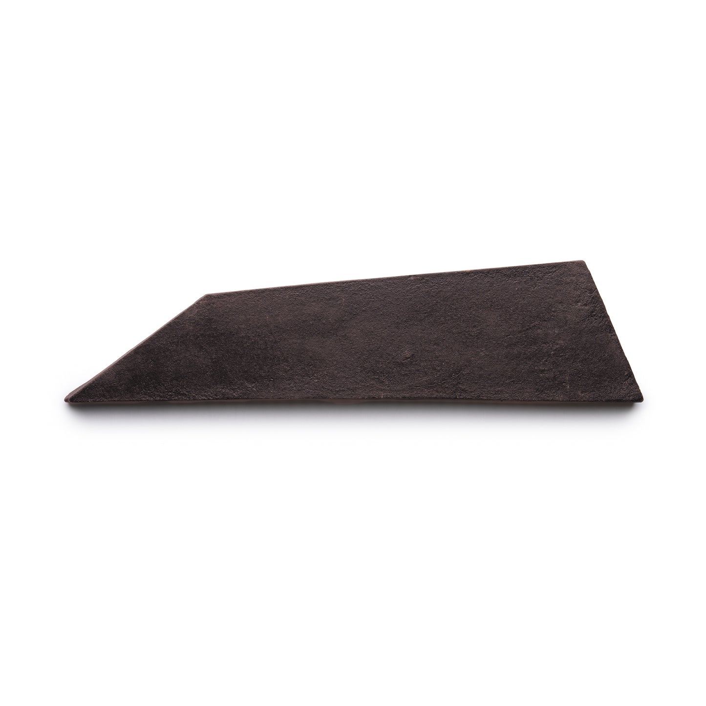 A single, irregularly shaped Tornillo + Oscura tile by Zia Tile, dark brown in color with a flat surface and angular, uneven edges, lies on a white background.